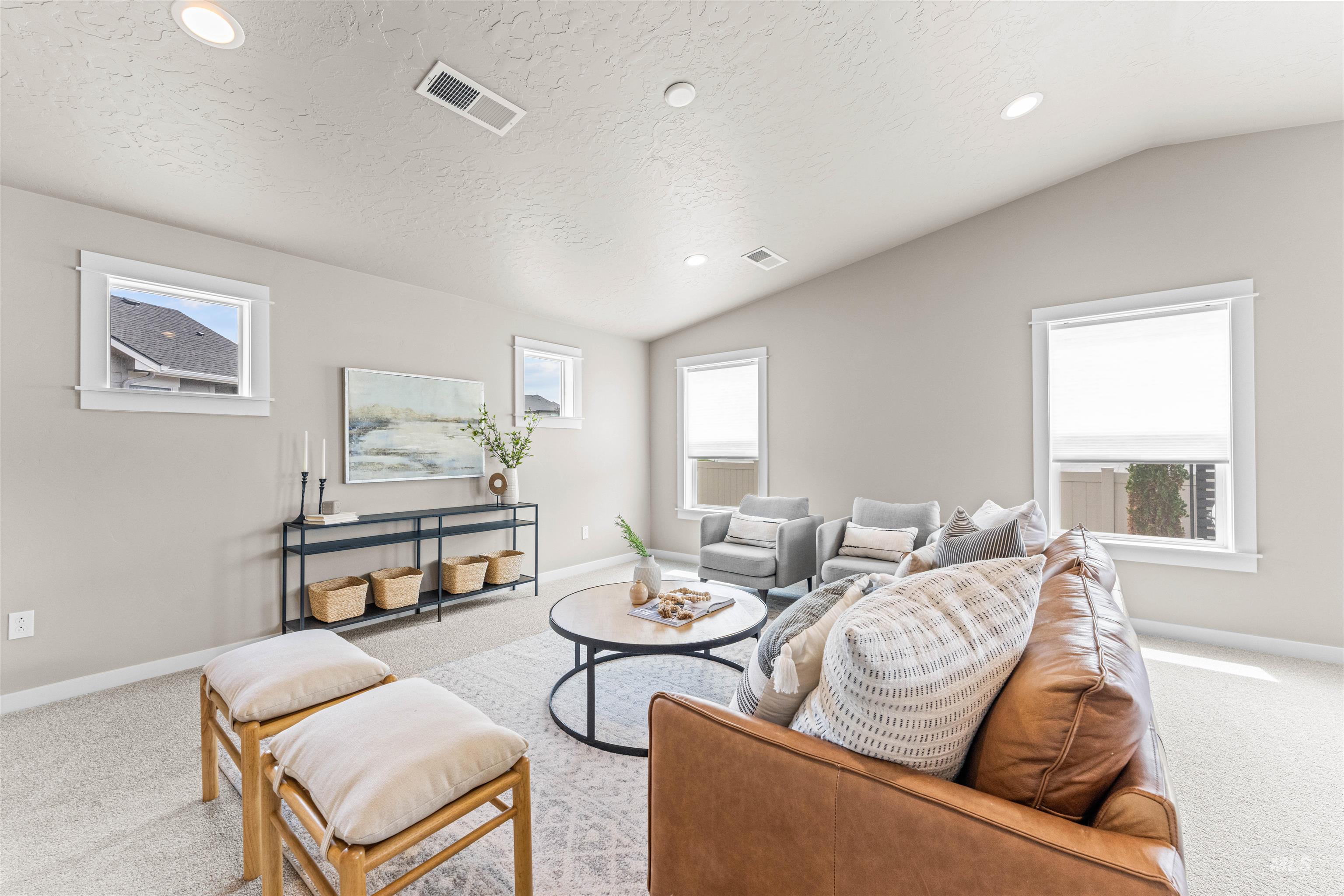 Carpeted living room featuring lofted ceiling, recessed lighting, healthy amount of natural light, and a textured ceiling