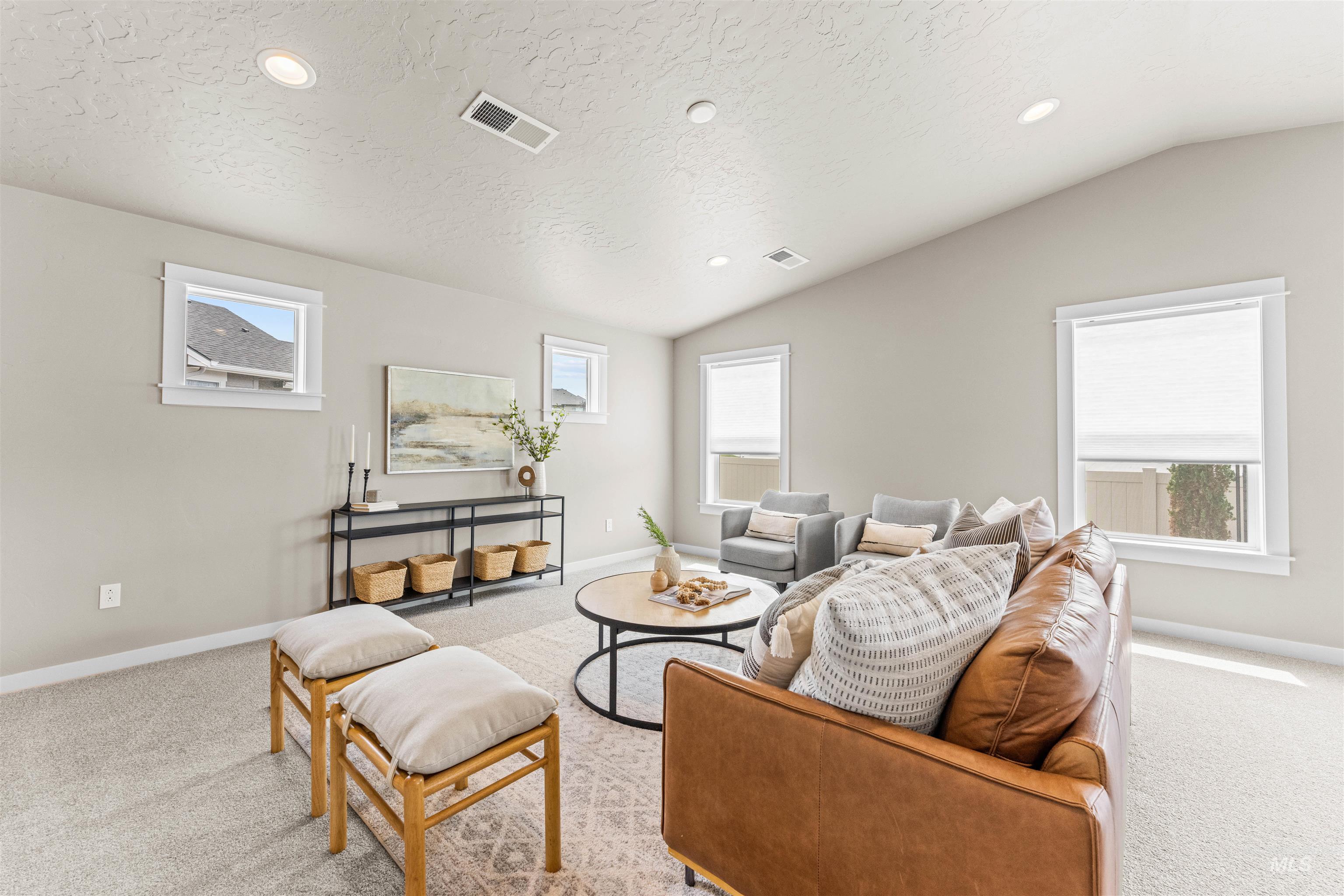 Living area featuring light colored carpet, lofted ceiling, recessed lighting, and a textured ceiling