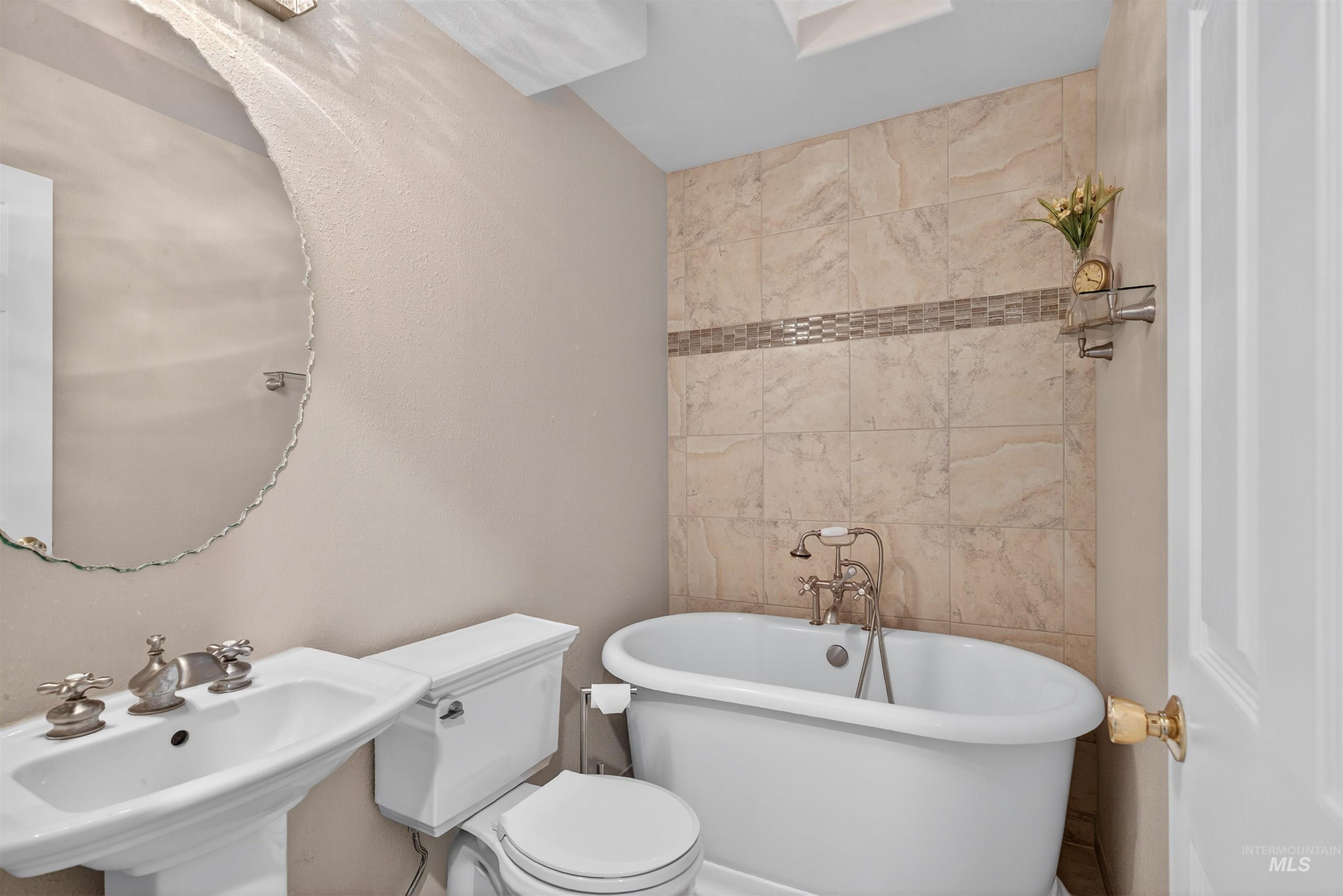 Full bathroom featuring tile walls and a freestanding tub