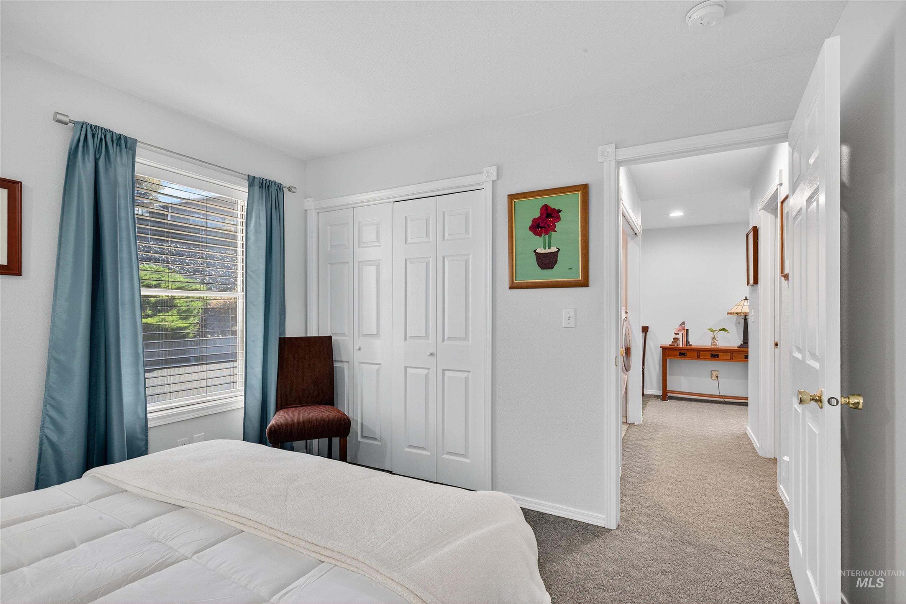 Carpeted bedroom with baseboards and a closet