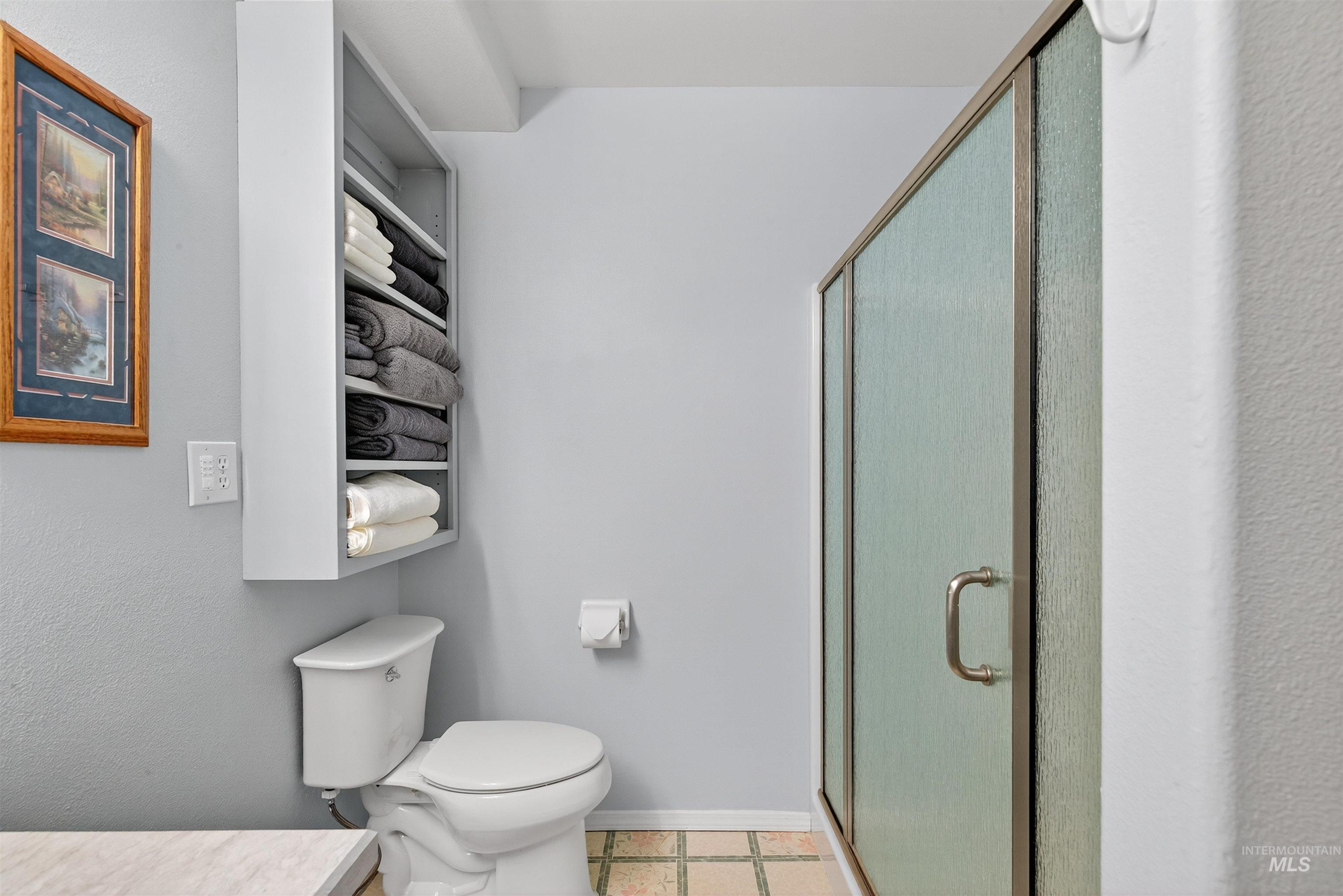 Bathroom with vanity, a stall shower, and light tile patterned flooring