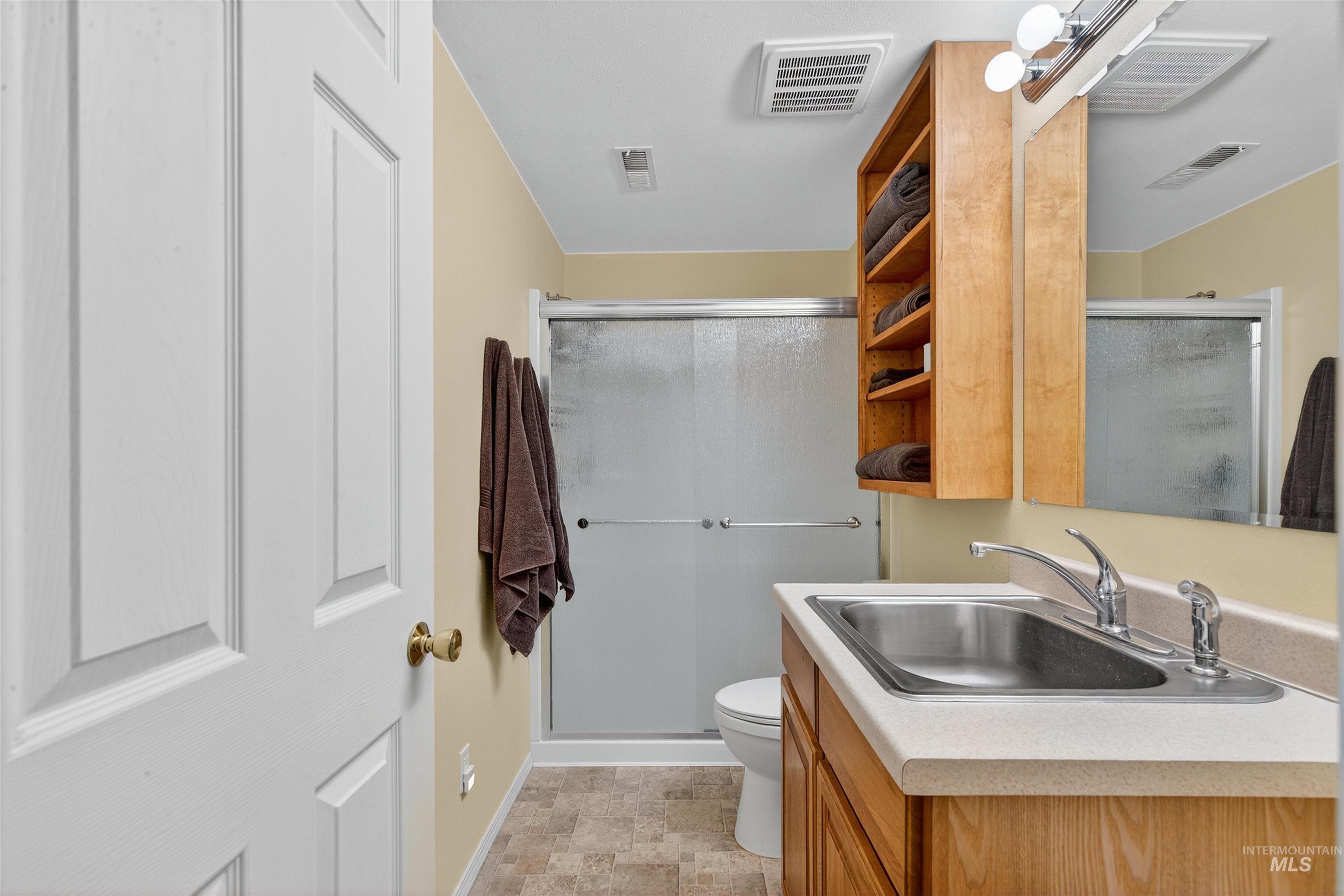 Full bath featuring a stall shower and vanity