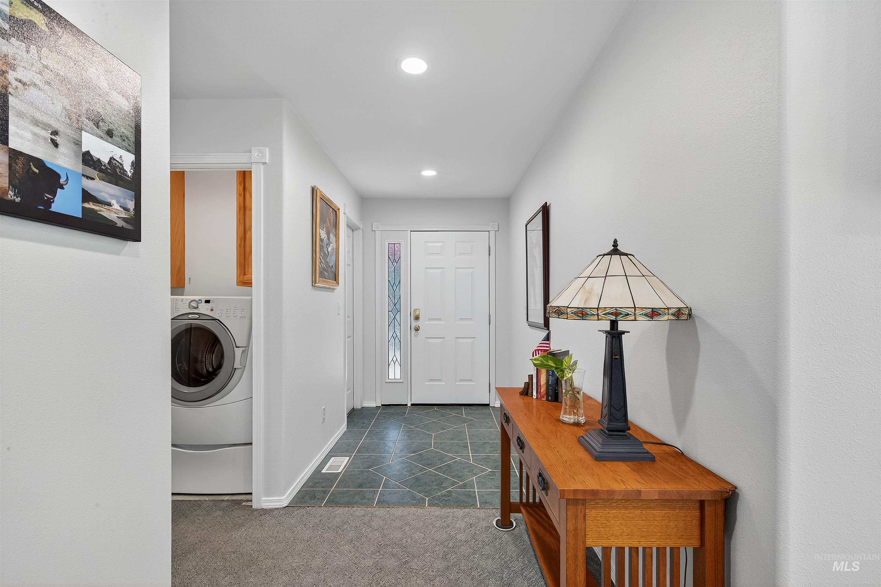 Washroom with washer / clothes dryer, dark carpet, cabinet space, dark tile patterned flooring, and recessed lighting