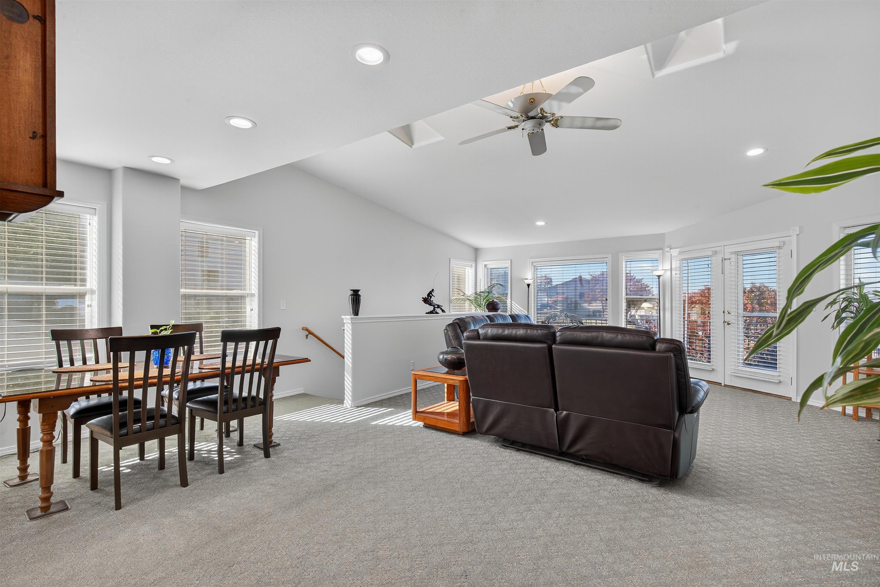 Living room featuring light carpet, recessed lighting, ceiling fan, and a city view