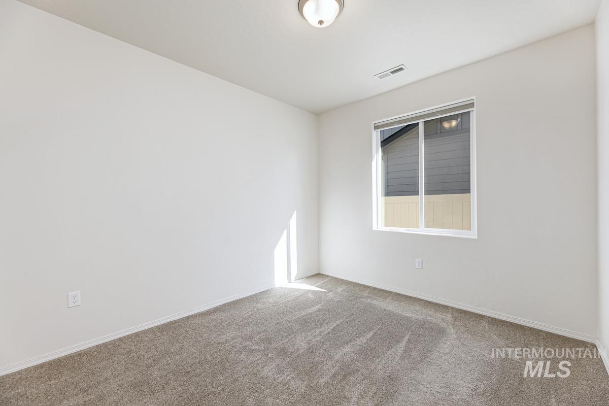 Spare room featuring carpet and baseboards