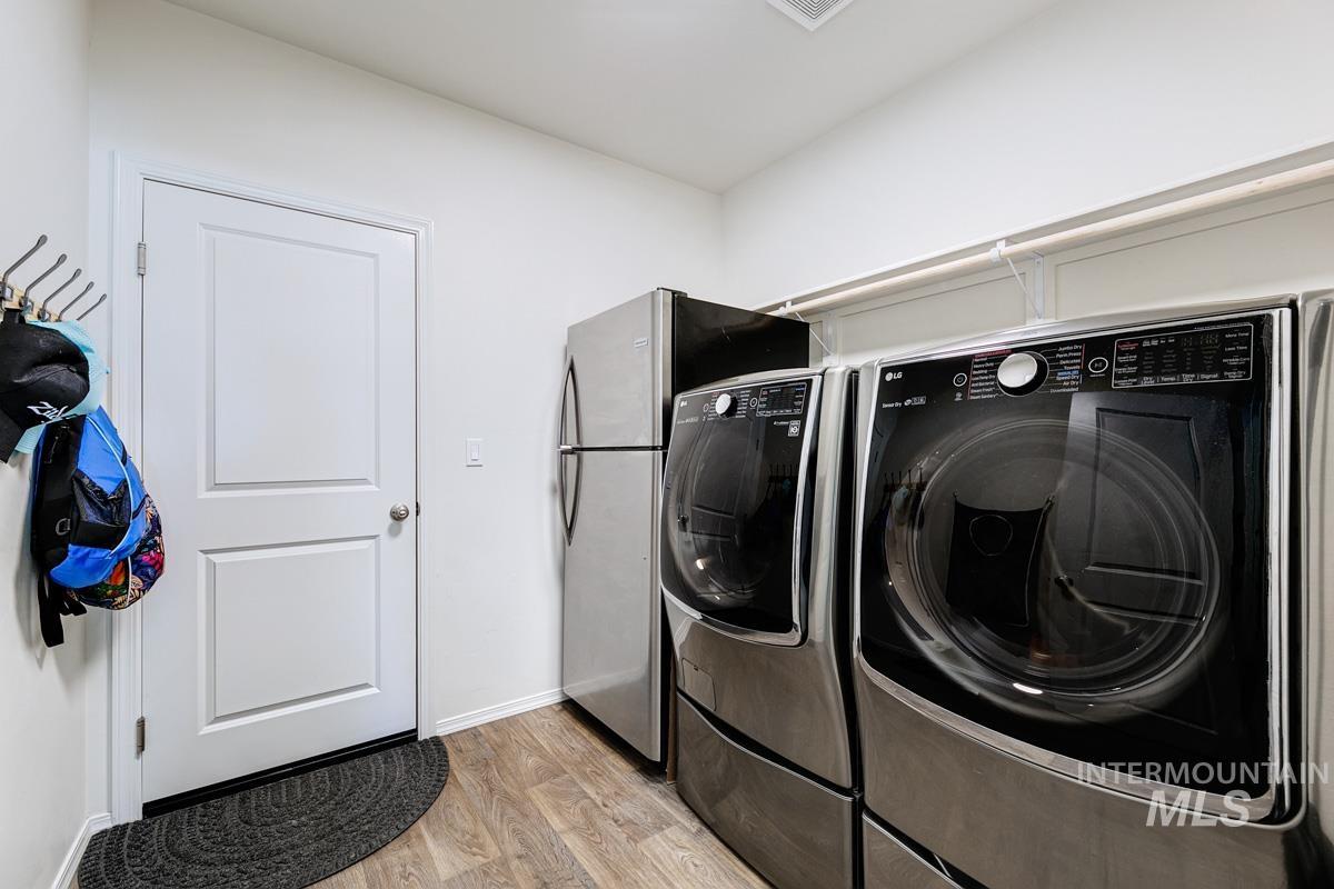 Washroom featuring light wood-style flooring and washer and dryer