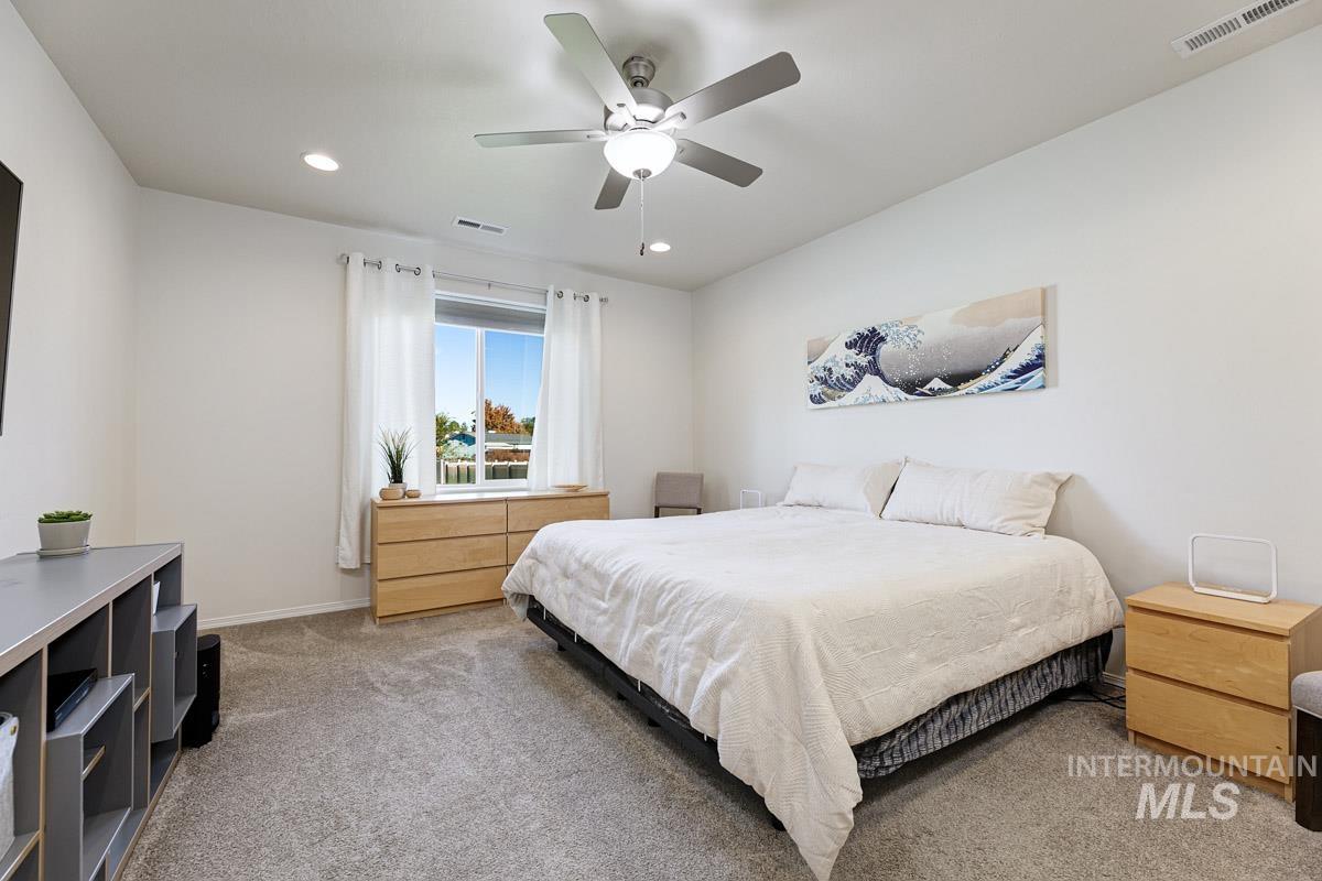 Bedroom with light carpet, a ceiling fan, and recessed lighting