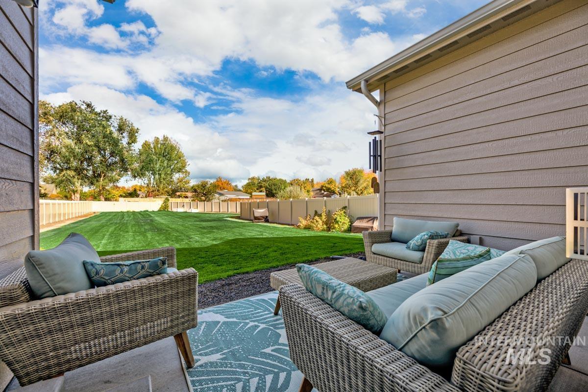 Fenced backyard featuring an outdoor hangout area and a patio