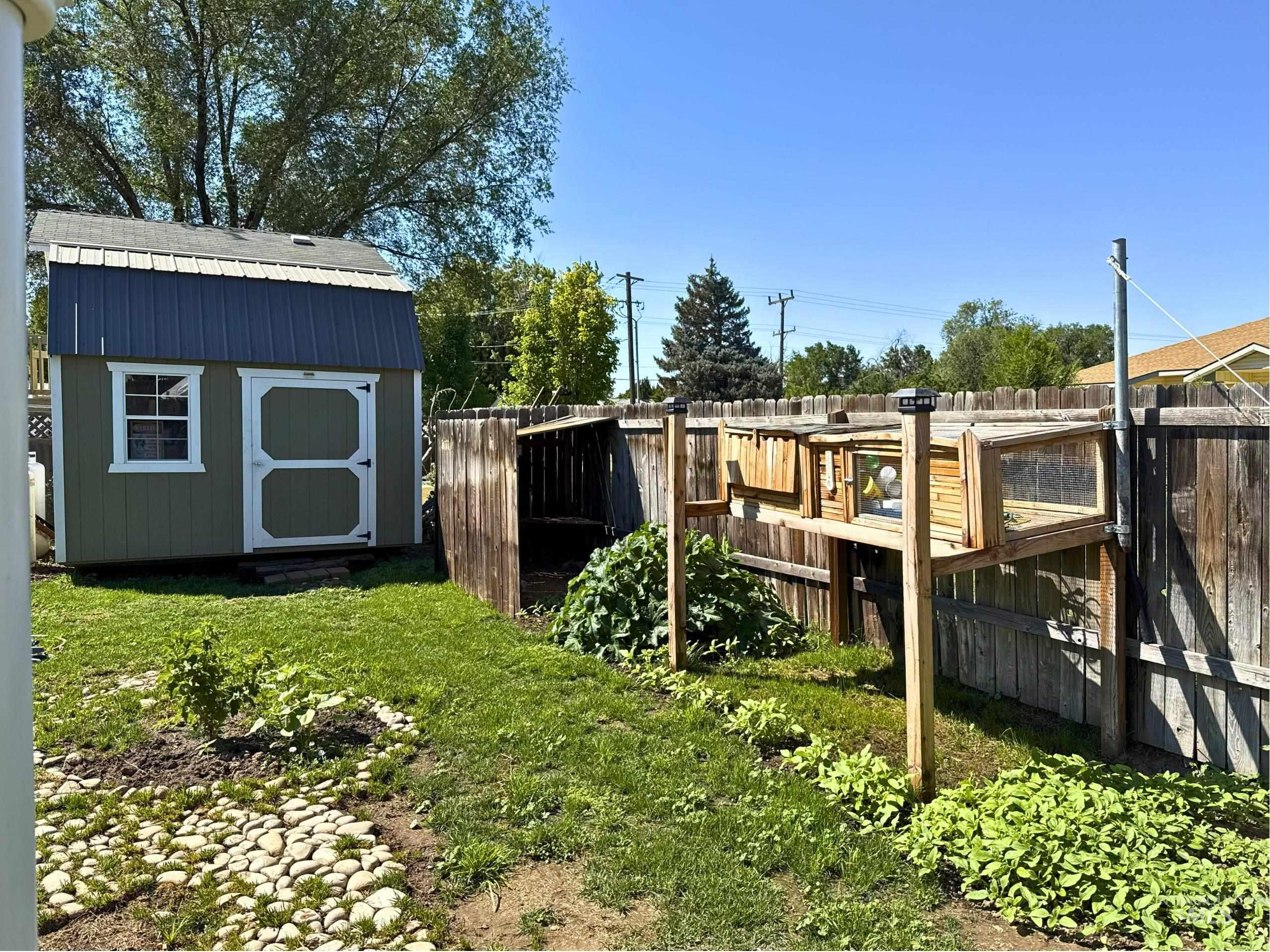 Fenced backyard featuring a storage shed