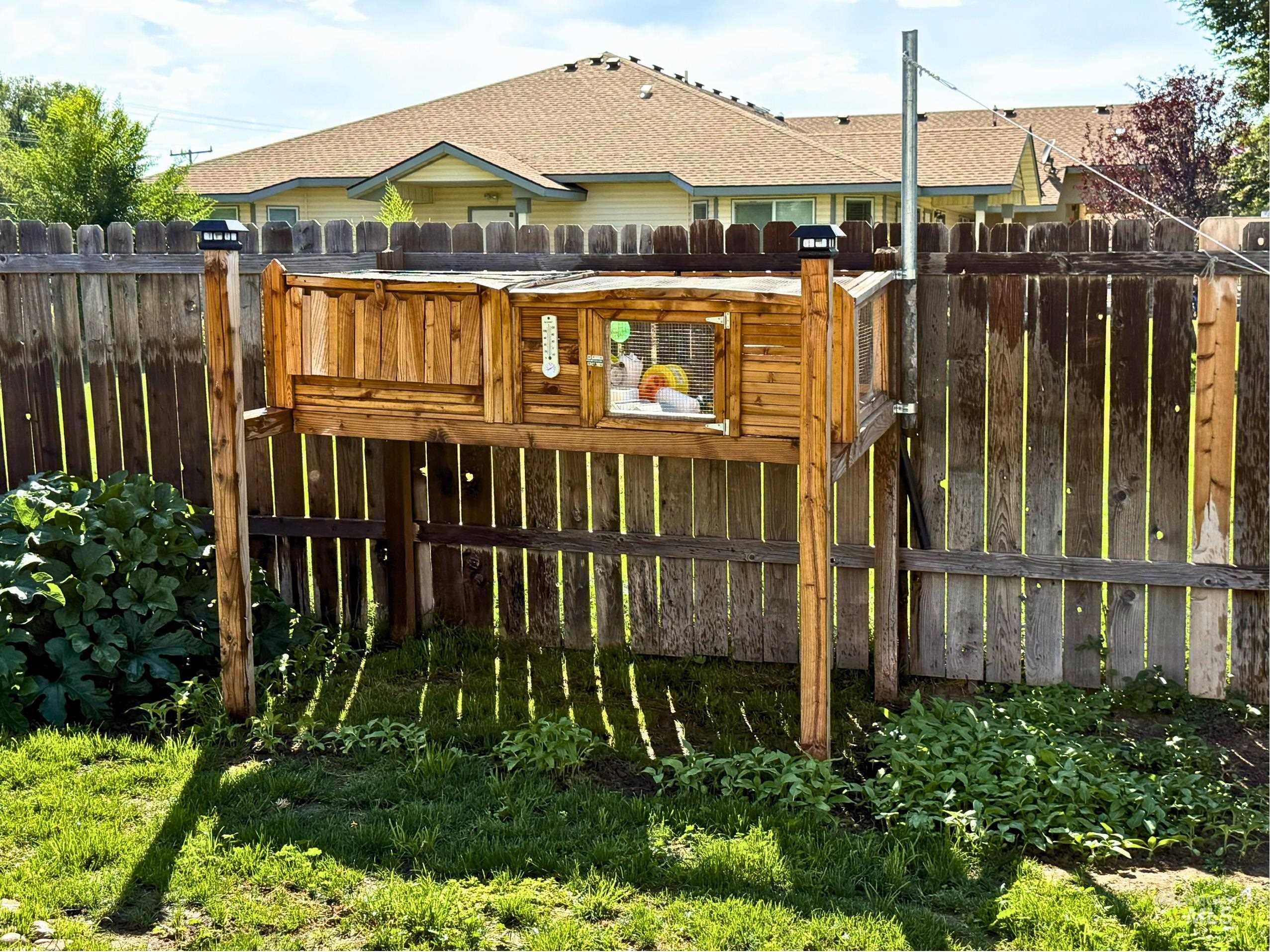 Back of house with a fenced backyard and roof with shingles