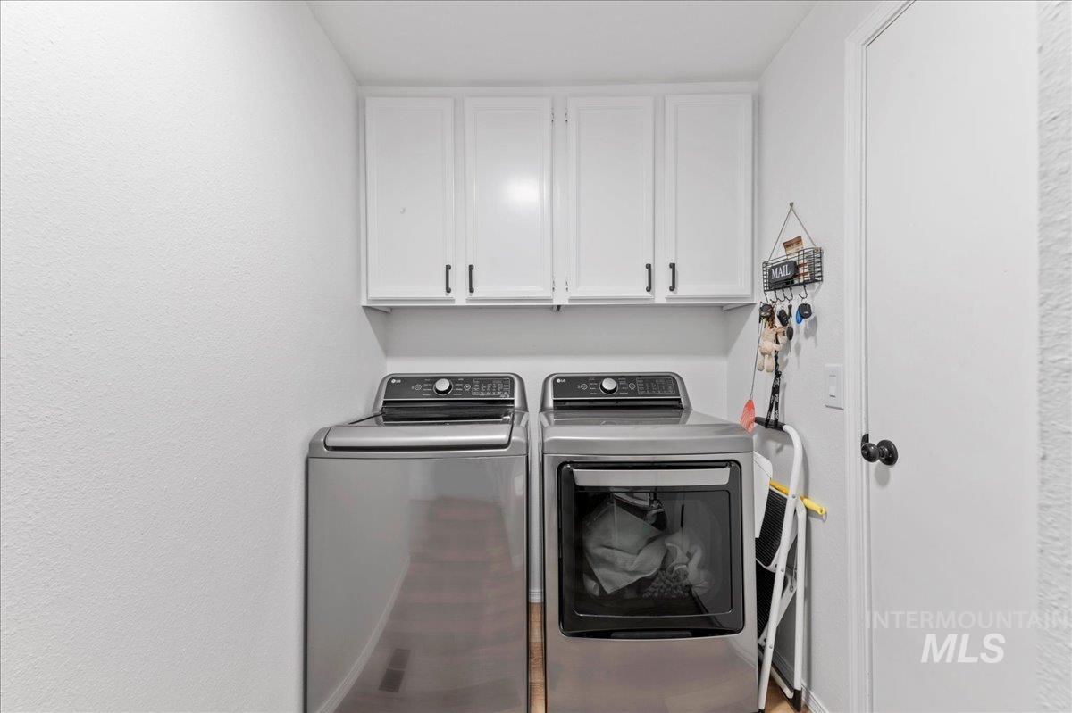 Washroom featuring cabinet space and washer and dryer