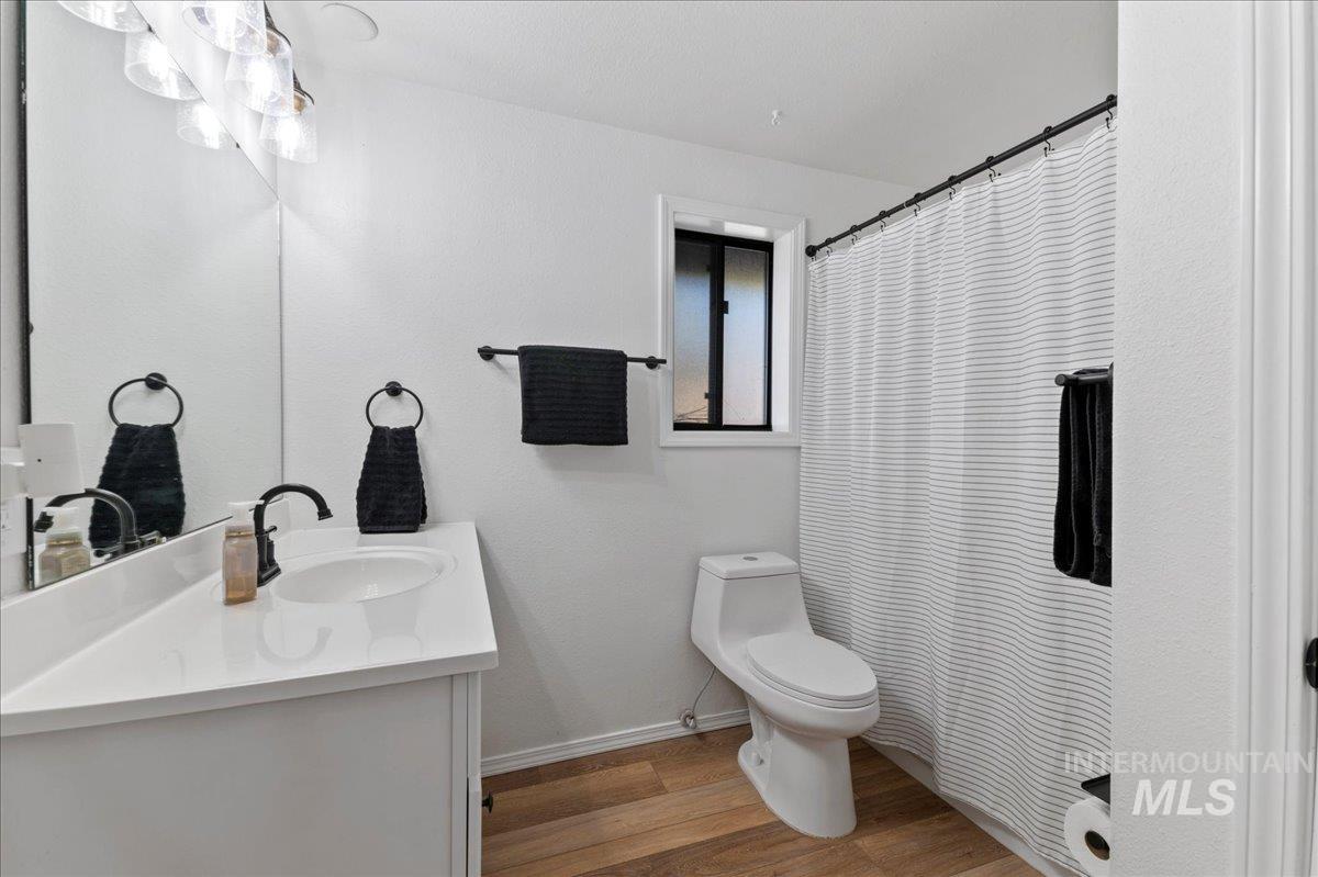 Bathroom featuring wood finished floors, vanity, and a shower with curtain