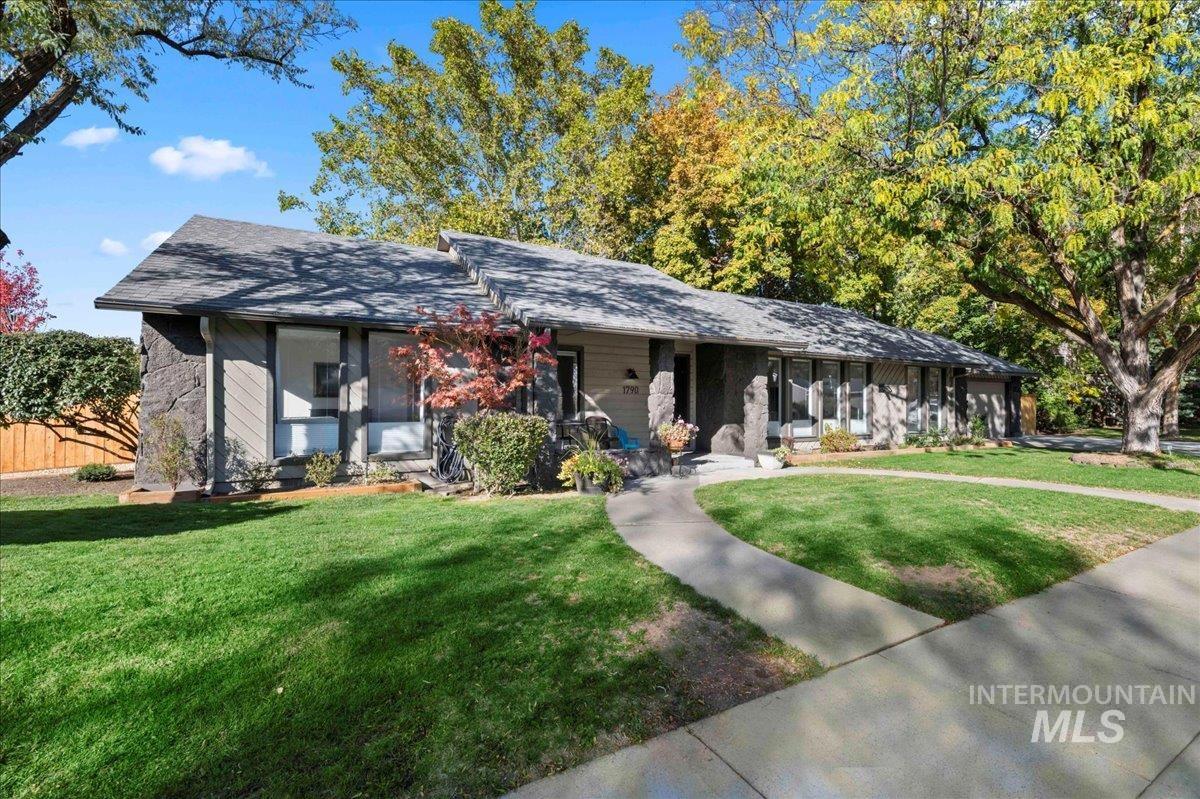 Ranch-style home featuring a front lawn, a porch, and roof with shingles