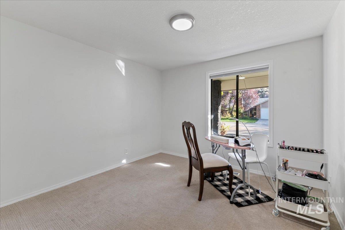 Office space featuring light colored carpet and a textured ceiling