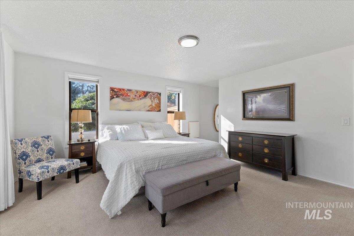 Bedroom featuring light colored carpet and a textured ceiling