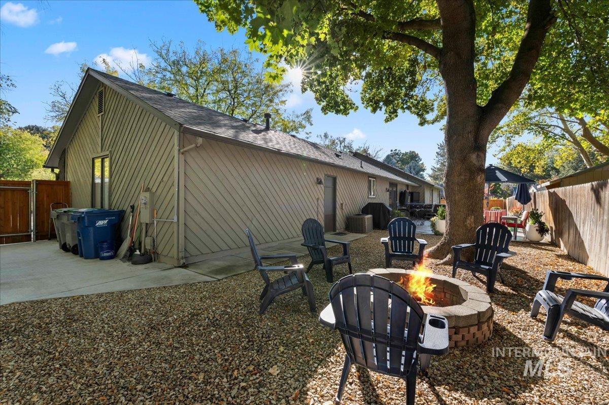 Rear view of property featuring a fenced backyard, a patio, and a shingled roof