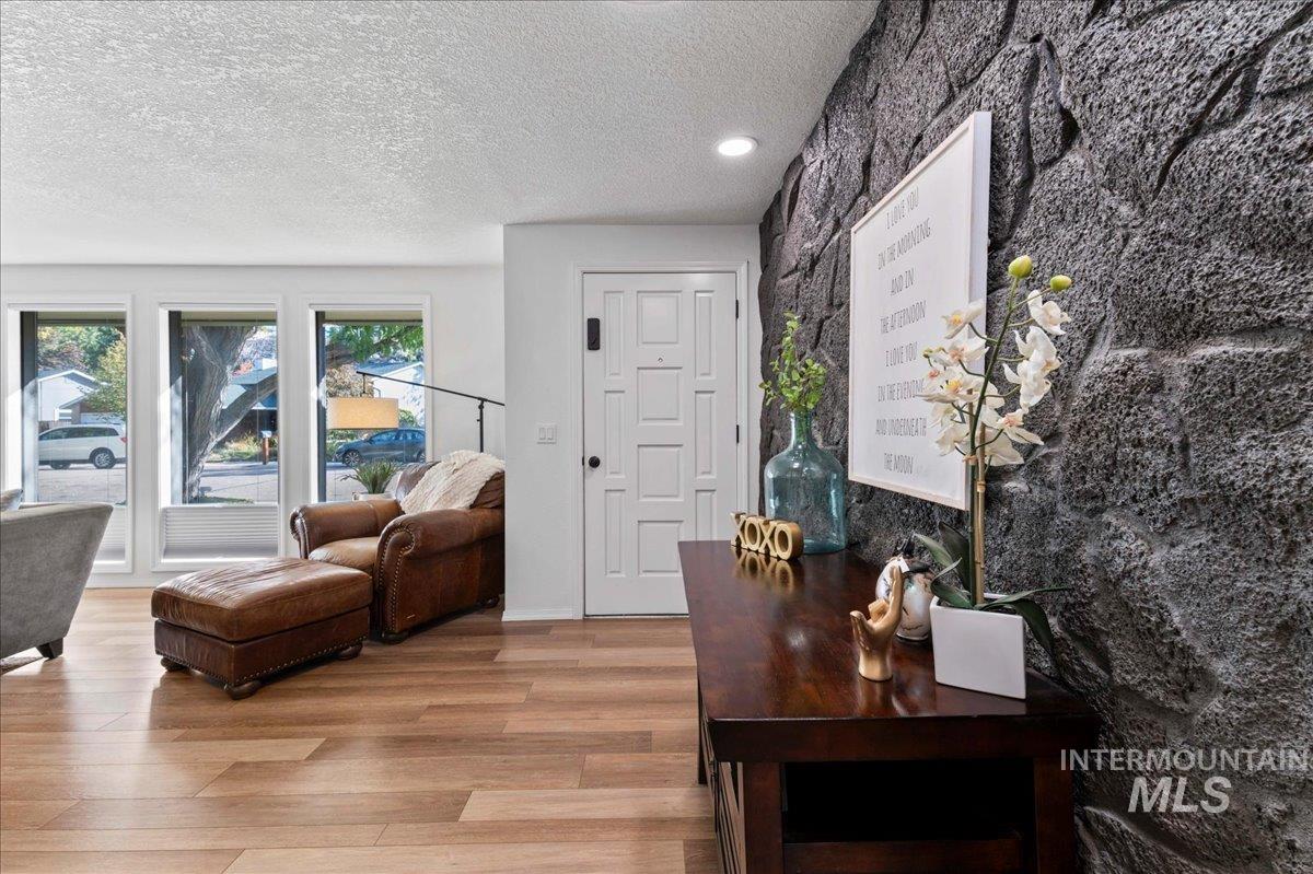 Office area with light wood-style floors and a textured ceiling