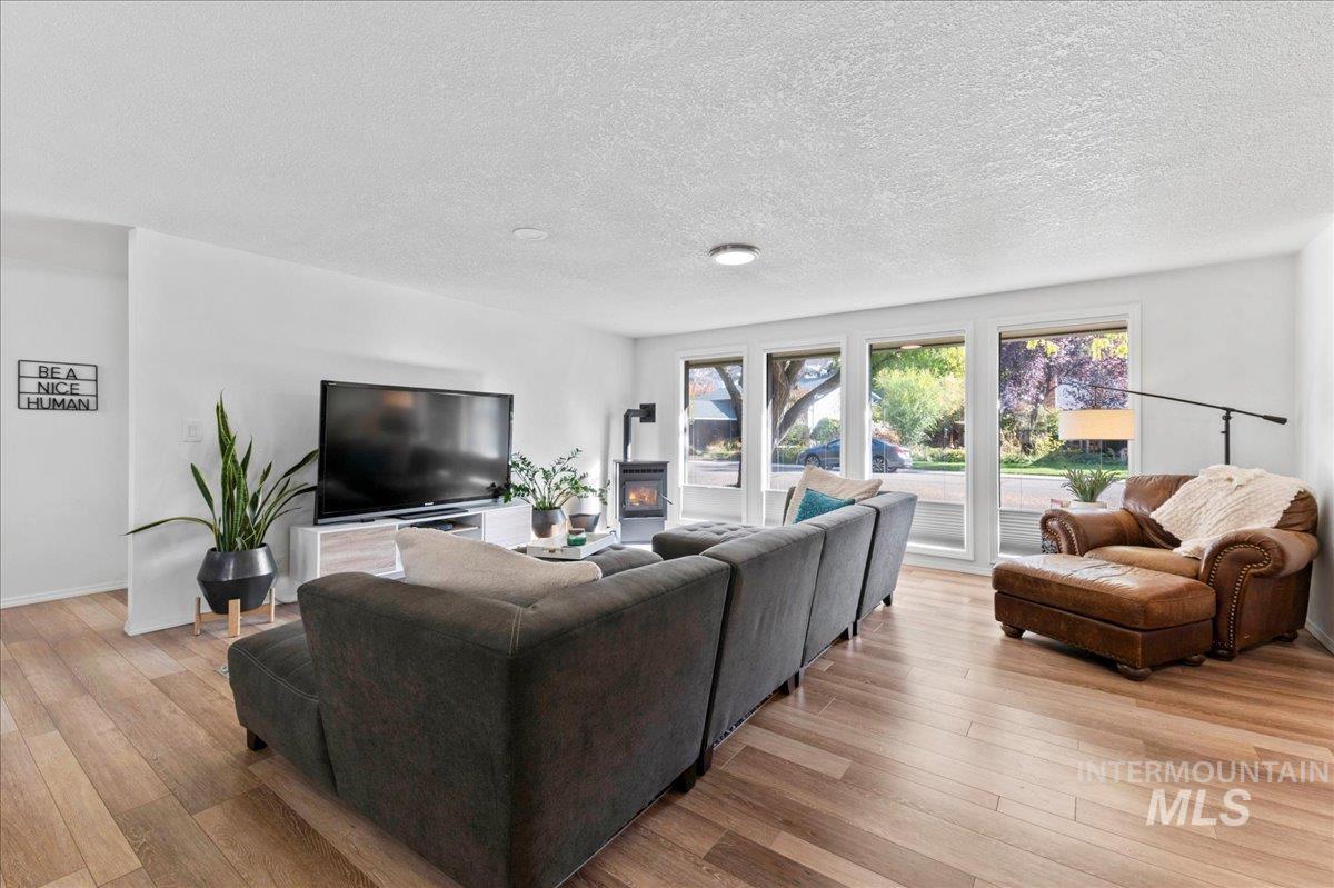 Living area with plenty of natural light, light wood finished floors, and a textured ceiling