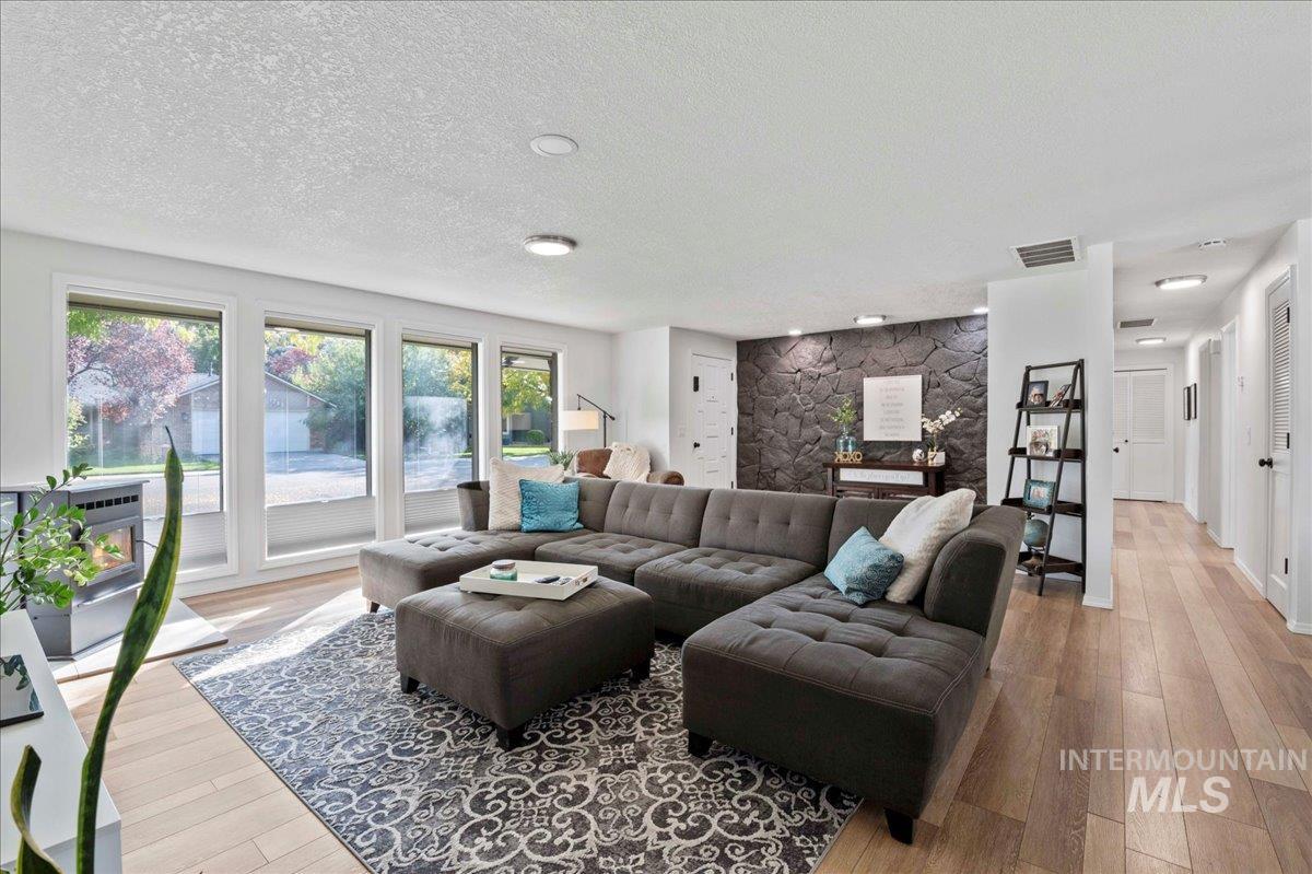 Living area with light wood-style floors and a textured ceiling