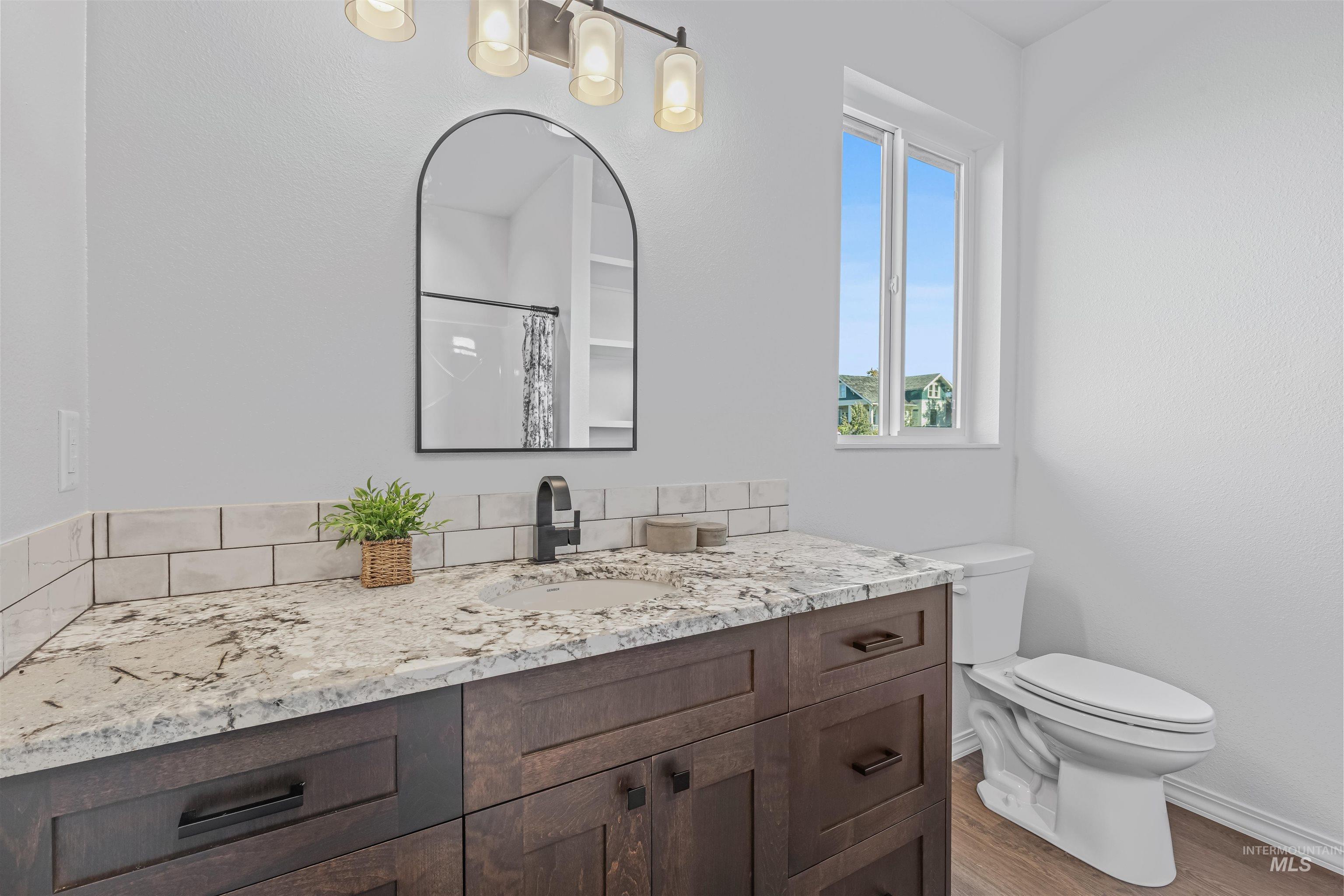 Bathroom with a shower with curtain, vanity, and wood finished floors