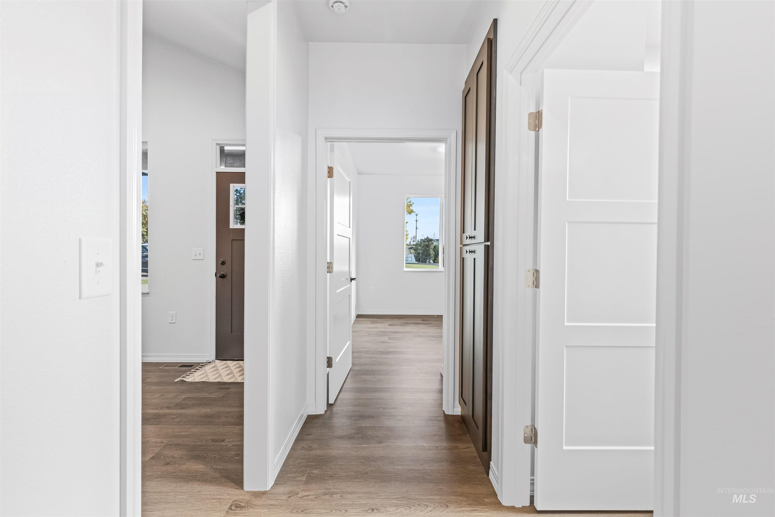 Corridor with light wood-style floors and baseboards