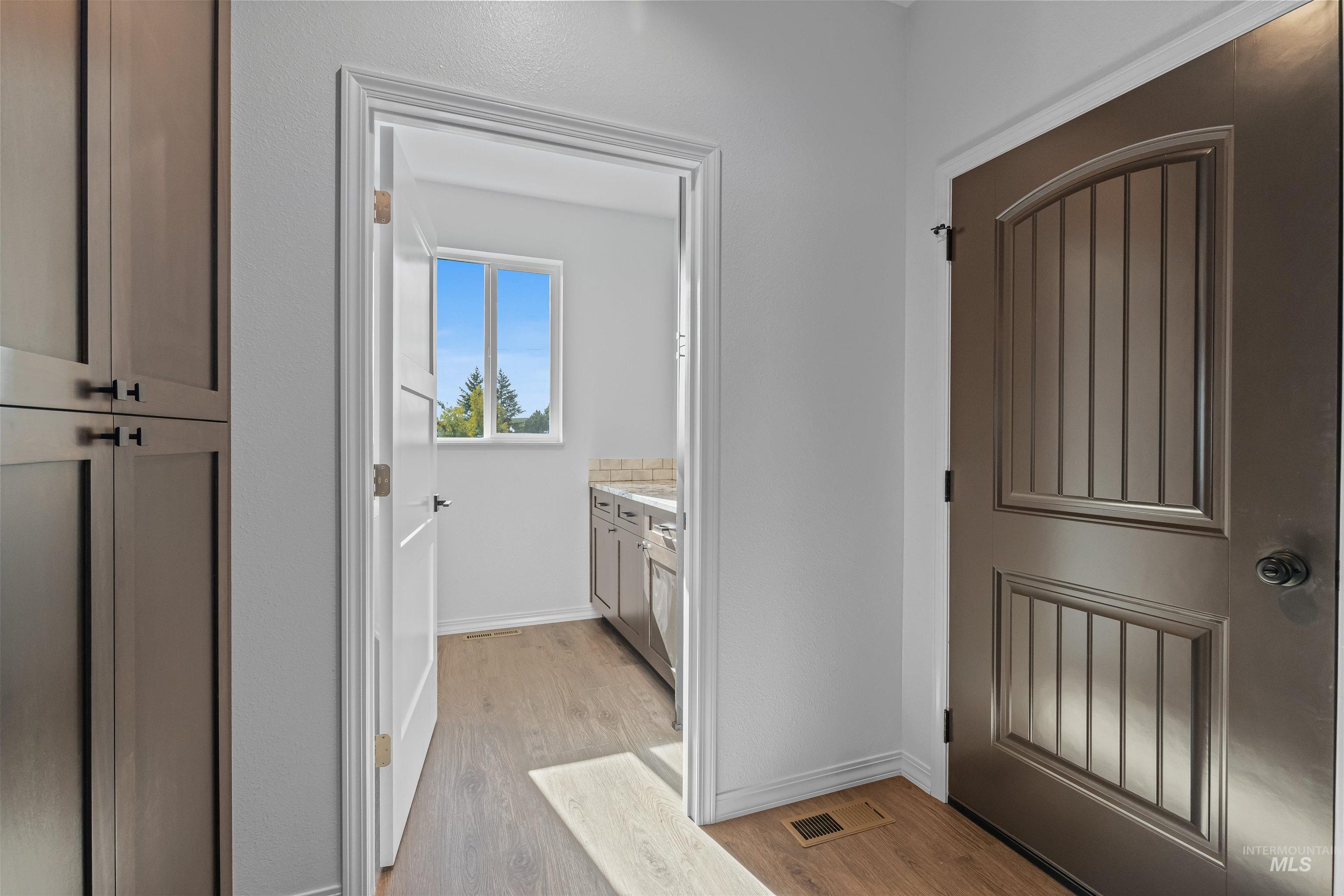 Doorway to outside with wood finished floors and baseboards
