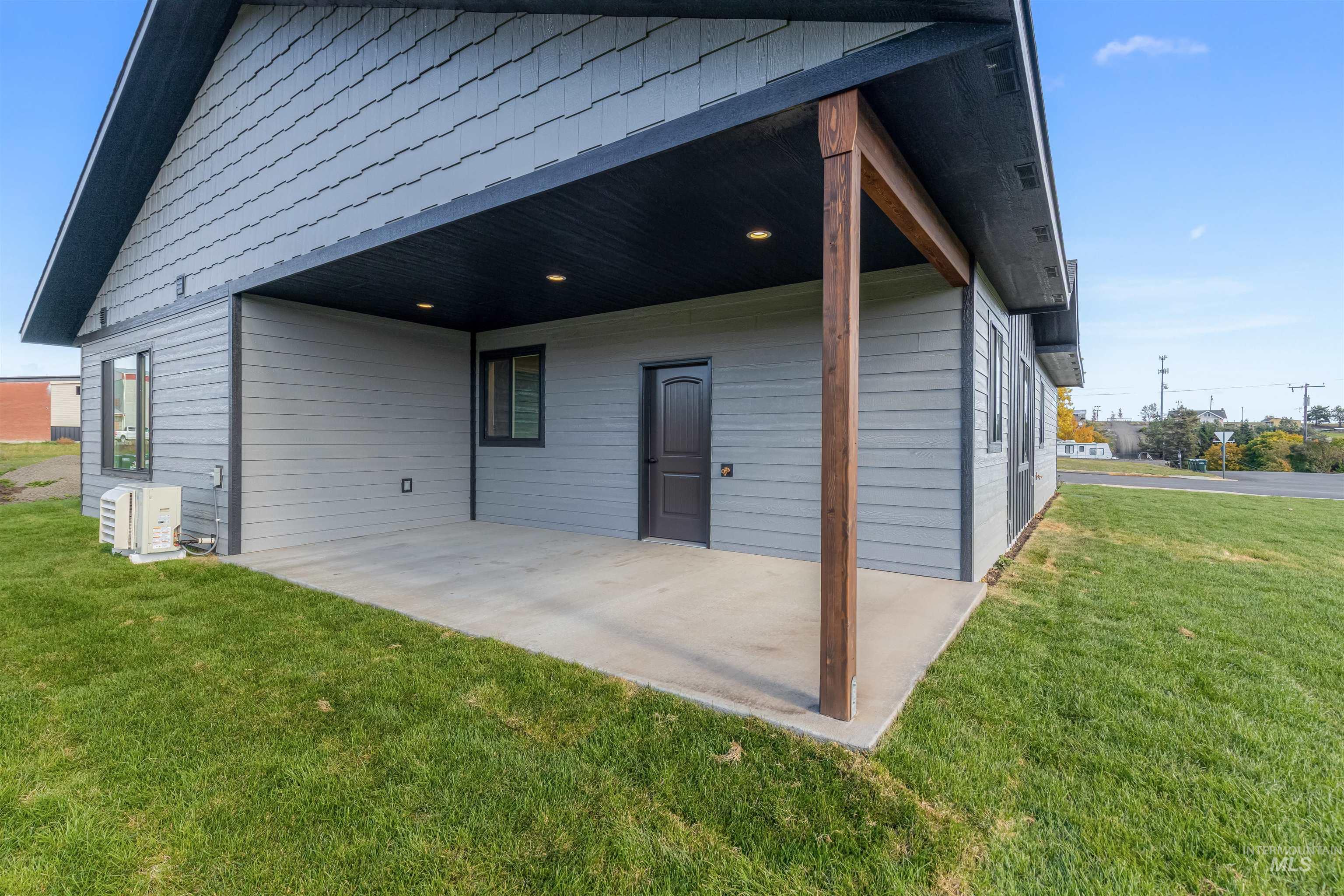Back of house with a patio area and a lawn