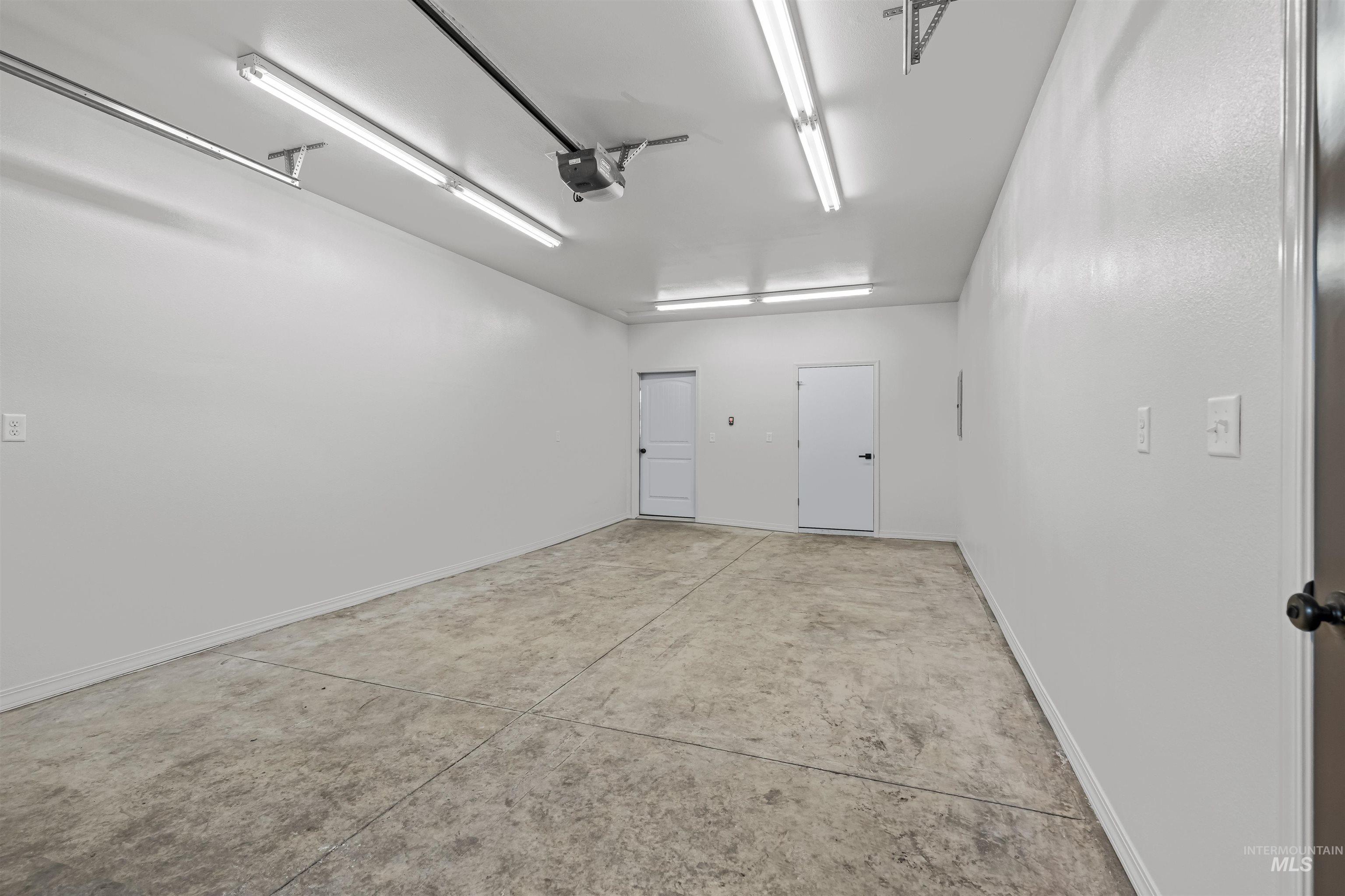Garage featuring baseboards and a garage door opener