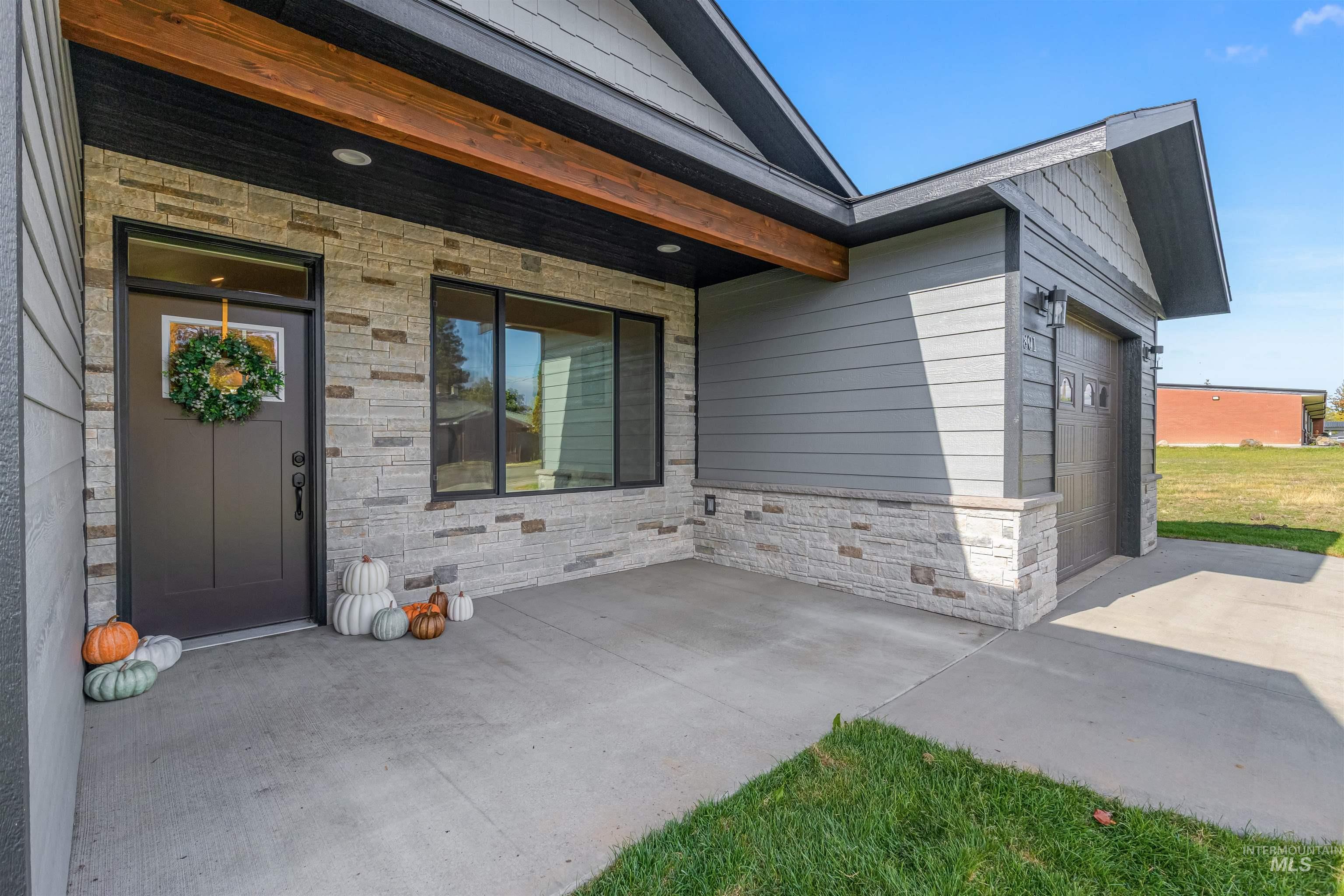 Property entrance featuring stone siding and a patio