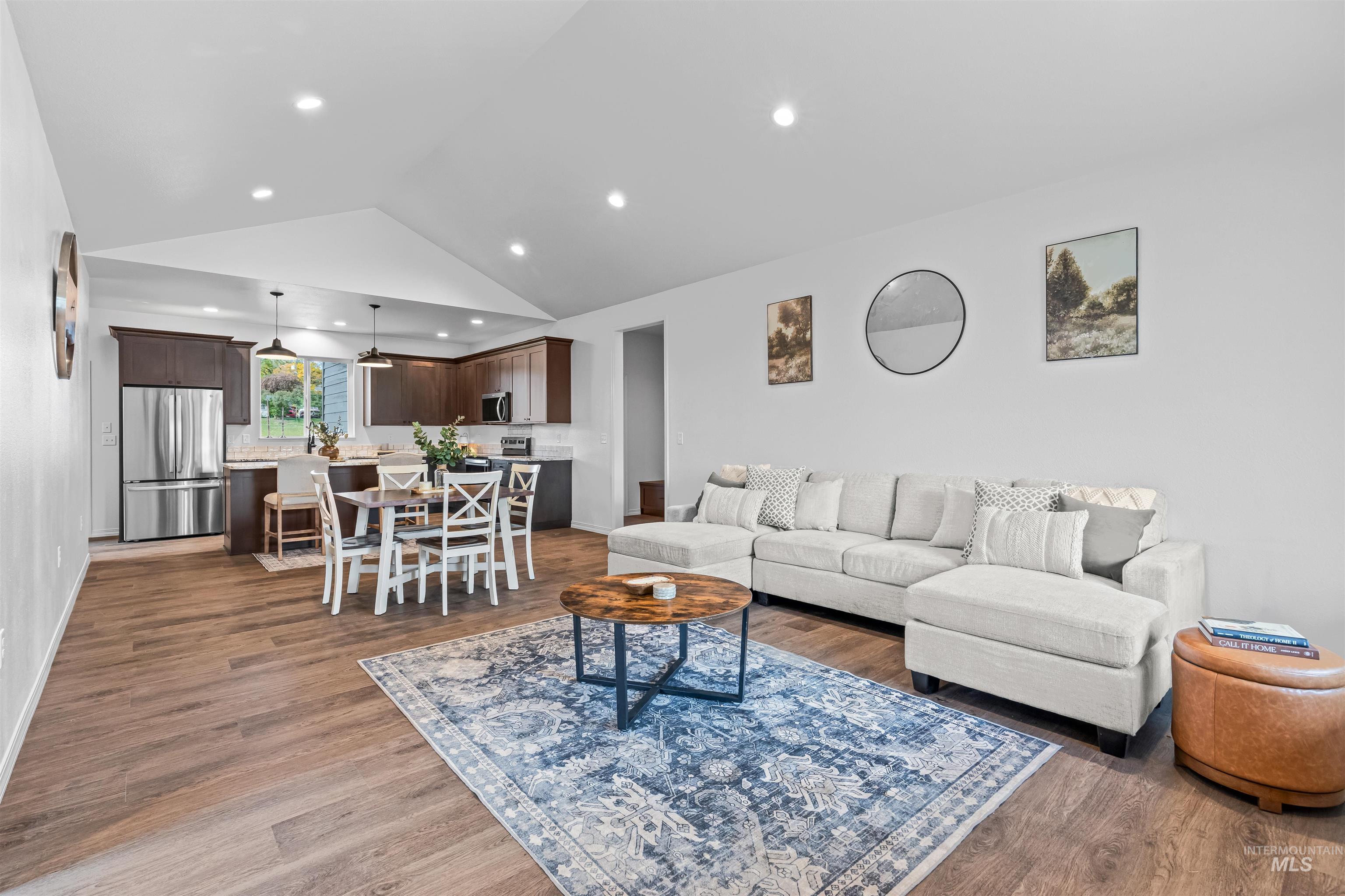 Living room featuring lofted ceiling, dark wood-style flooring, and recessed lighting