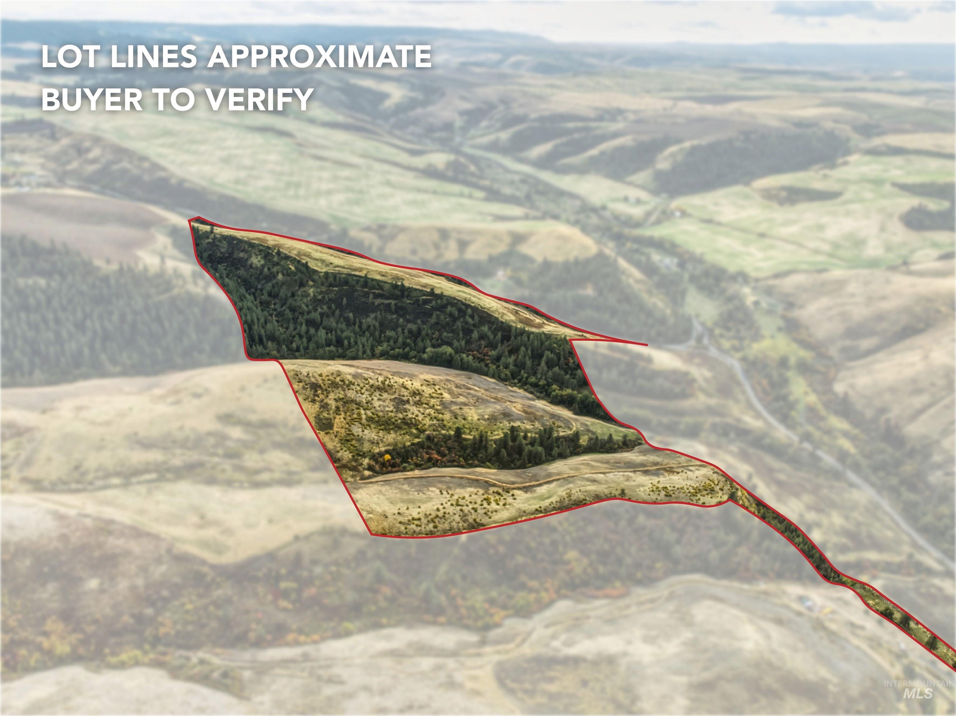 Aerial view of property and surrounding area featuring property boundaries highlighted and a mountainous background