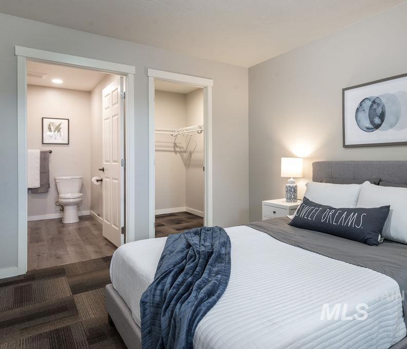 Bedroom with a walk in closet and wood finished floors