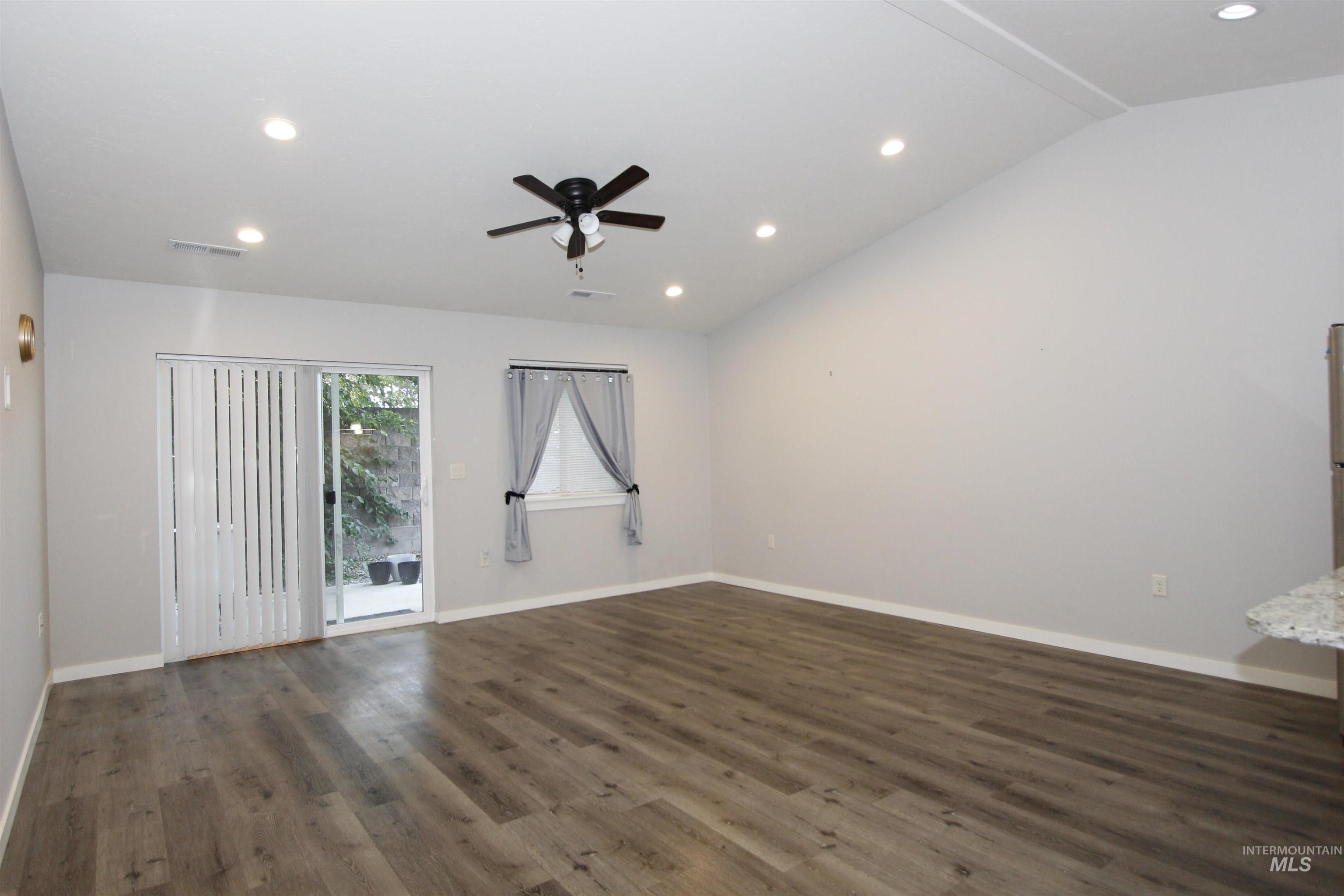 Unfurnished room featuring dark wood-style flooring, recessed lighting, ceiling fan, and lofted ceiling