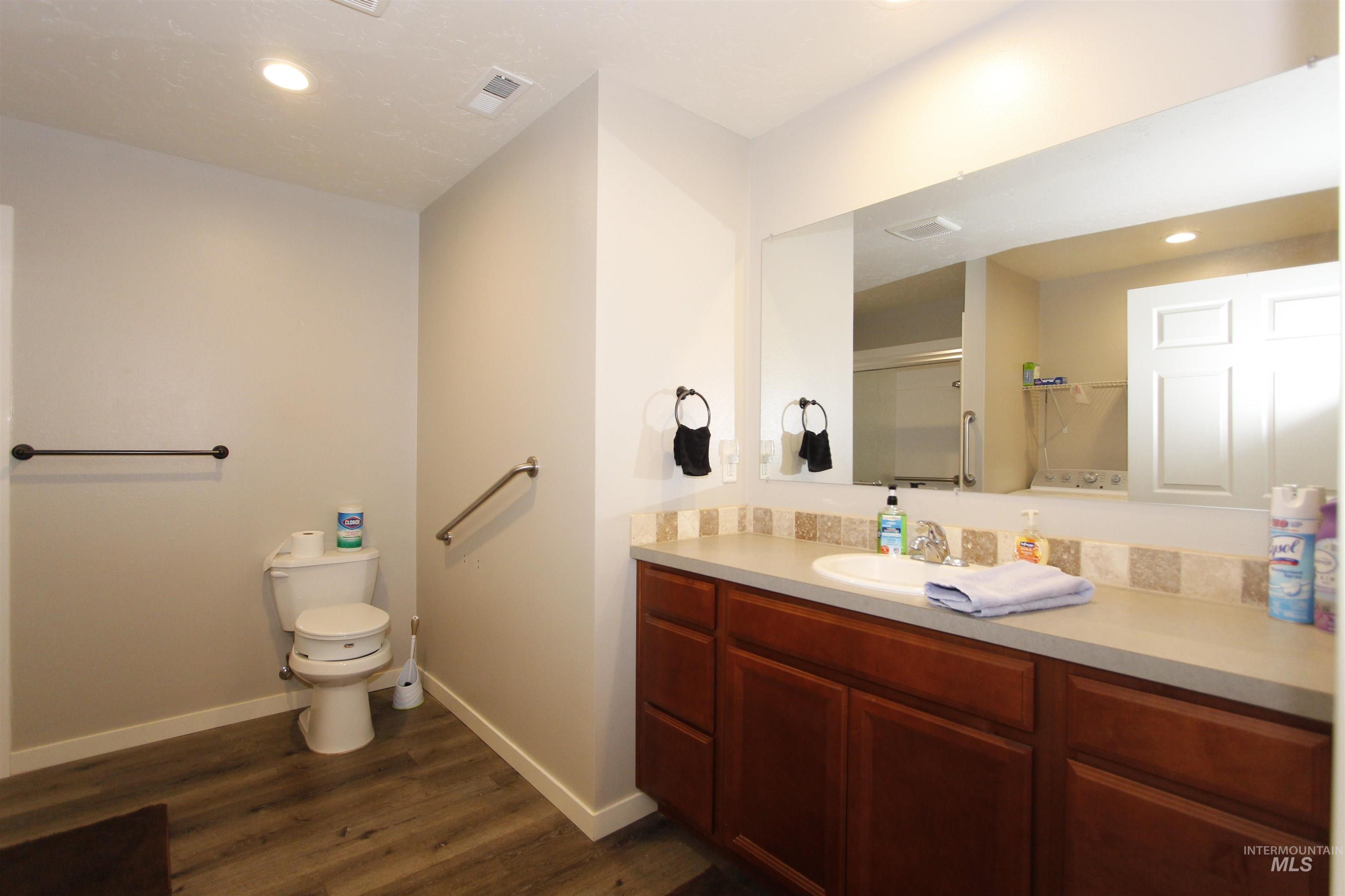 Bathroom with recessed lighting, vanity, dark wood-type flooring, and a shower stall