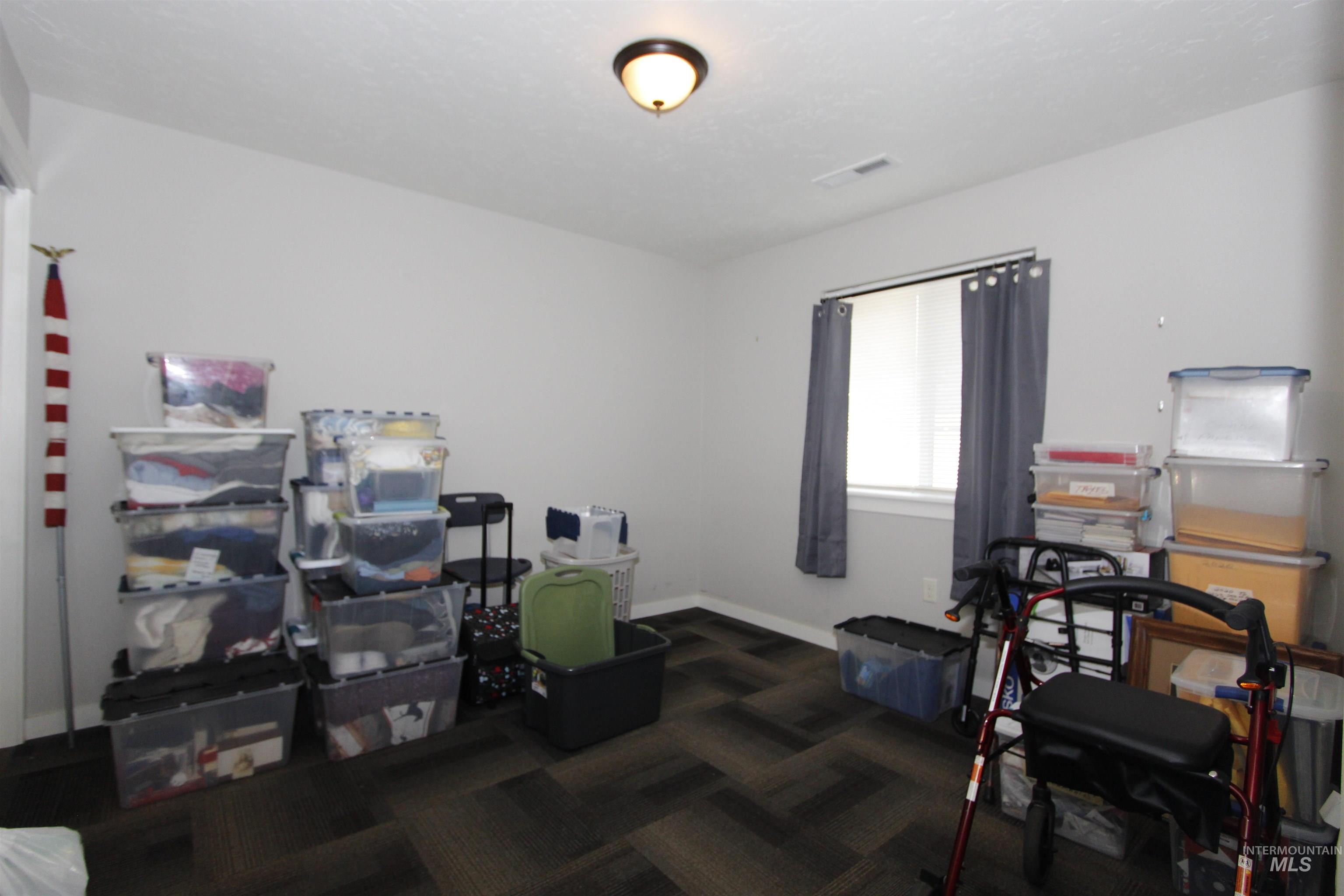 Office area with dark colored carpet and baseboards