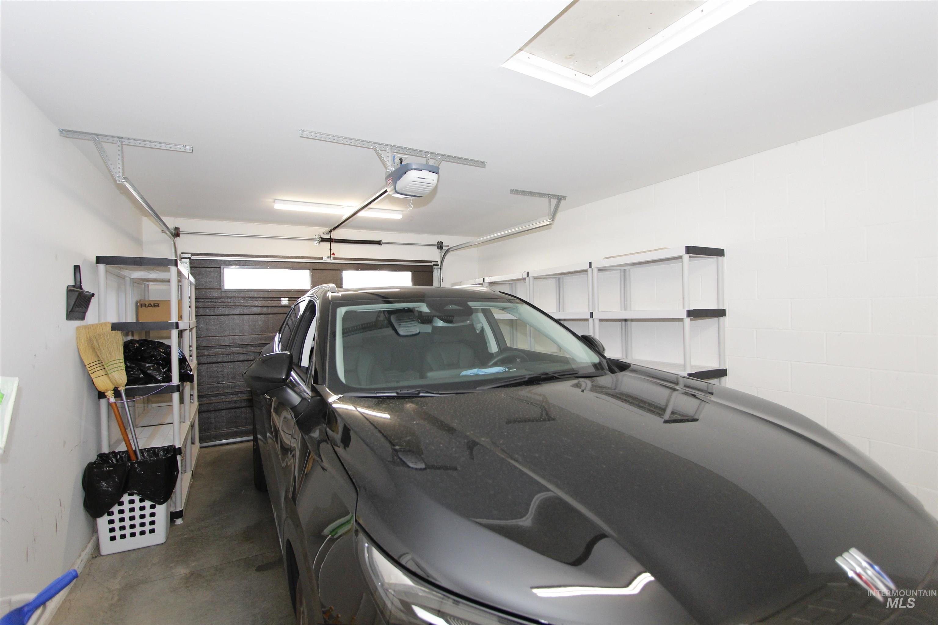 Garage with a garage door opener and baseboards