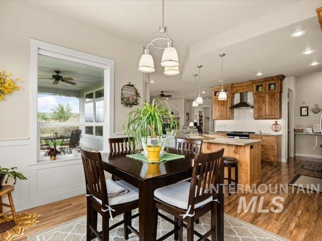 Dining room featuring dark wood-type flooring, a ceiling fan, and recessed lighting