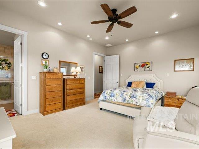 Bedroom with recessed lighting, light carpet, a ceiling fan, and ensuite bath
