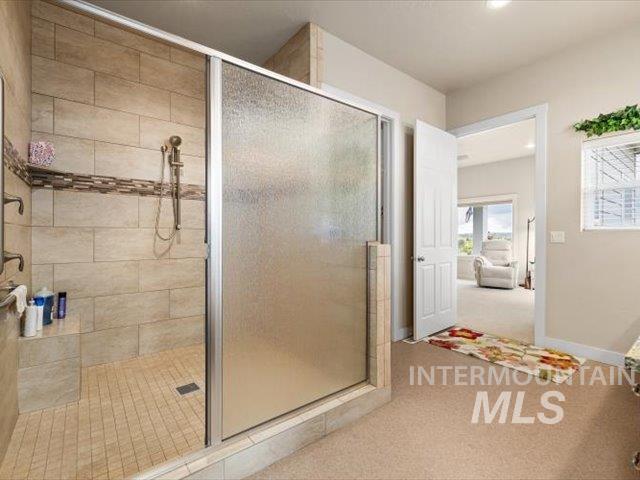Bathroom featuring a stall shower, light carpet, recessed lighting, and connected bathroom
