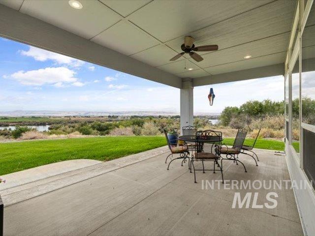 View of patio / terrace featuring outdoor dining area, ceiling fan, and a water view