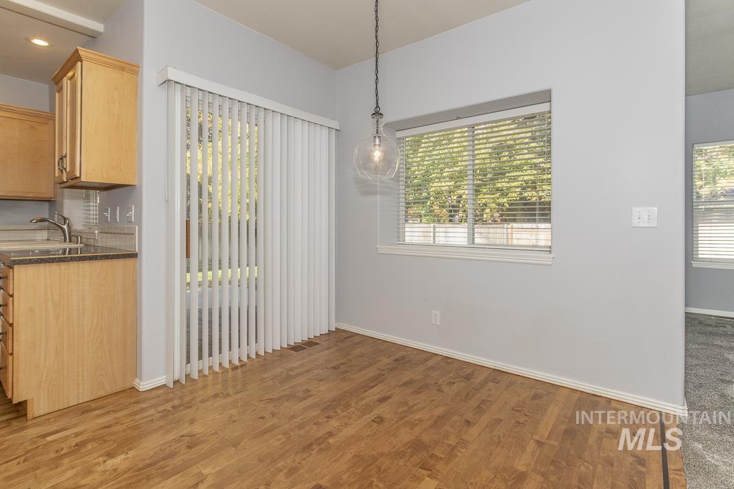 Unfurnished dining area with light wood-type flooring and baseboards