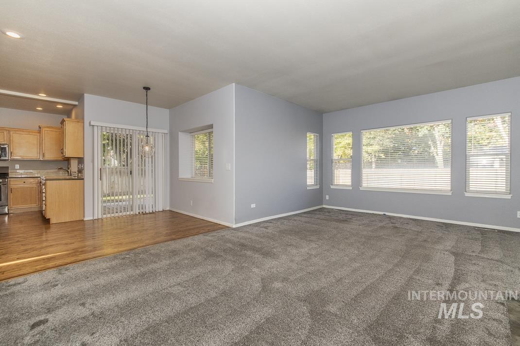Unfurnished living room with dark colored carpet and dark wood-type flooring