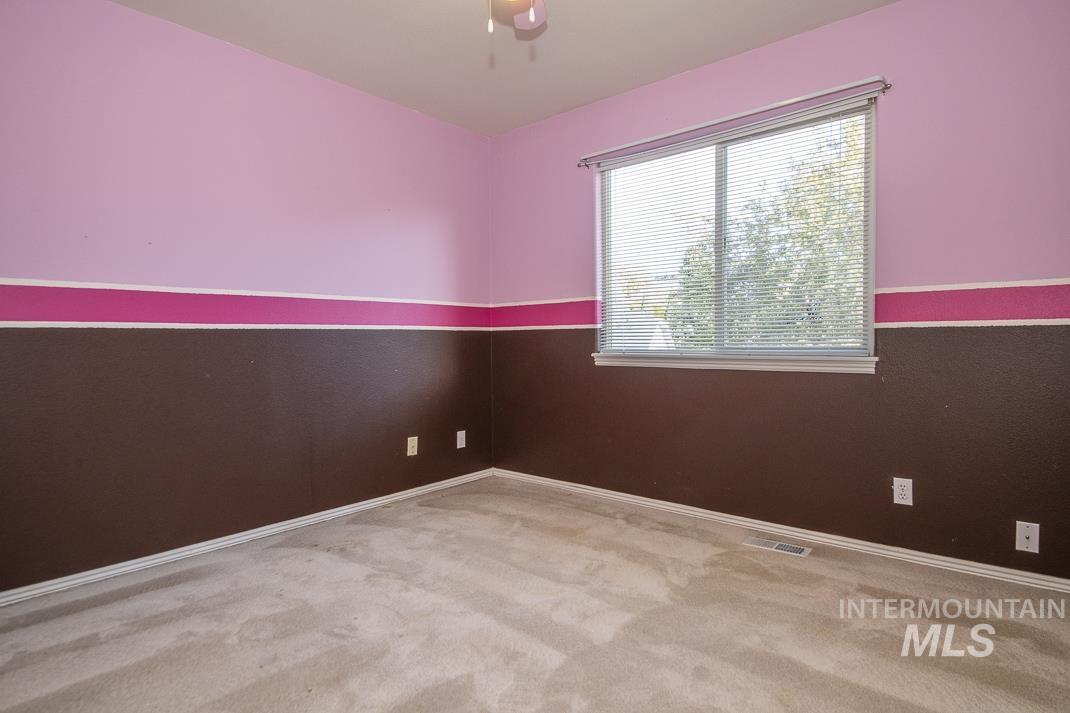 Empty room featuring light colored carpet and baseboards