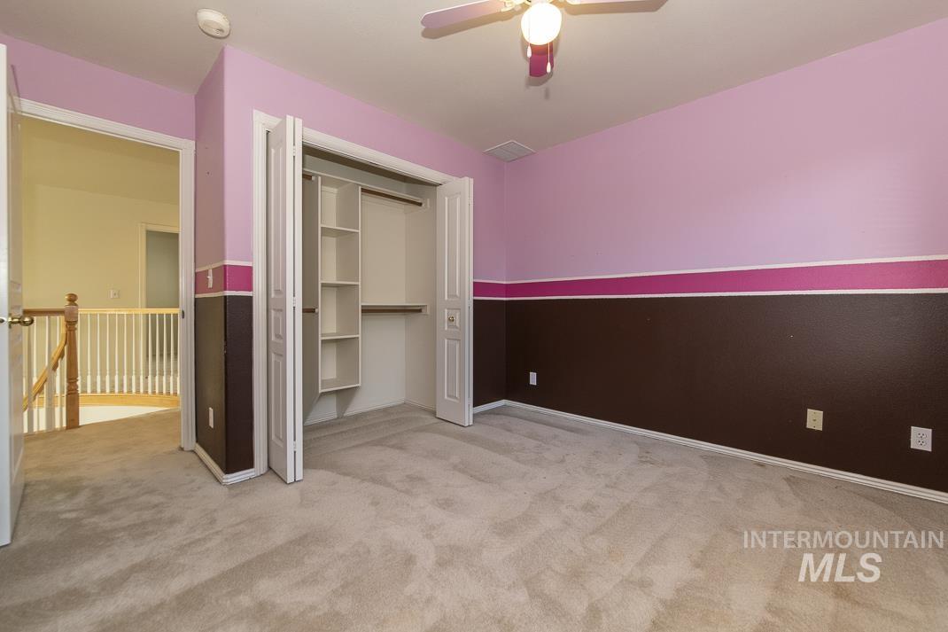 Unfurnished bedroom with light colored carpet, a closet, and ceiling fan