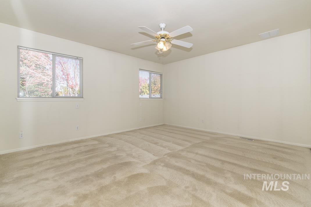 Spare room with light carpet and ceiling fan