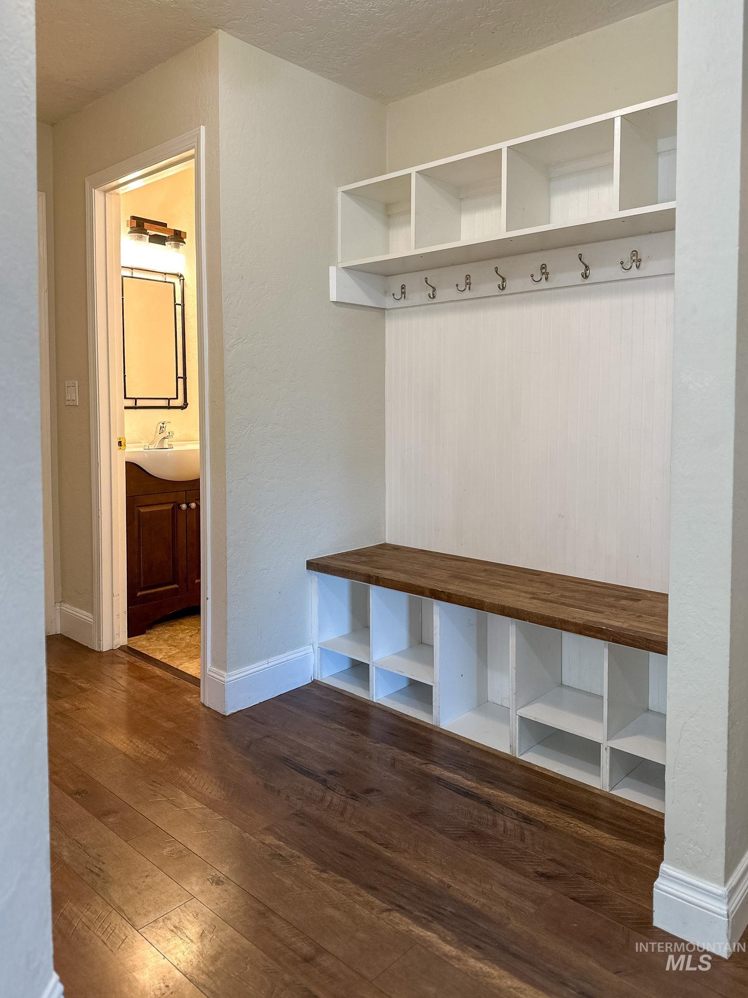 Mudroom featuring dark wood finished floors and a textured ceiling