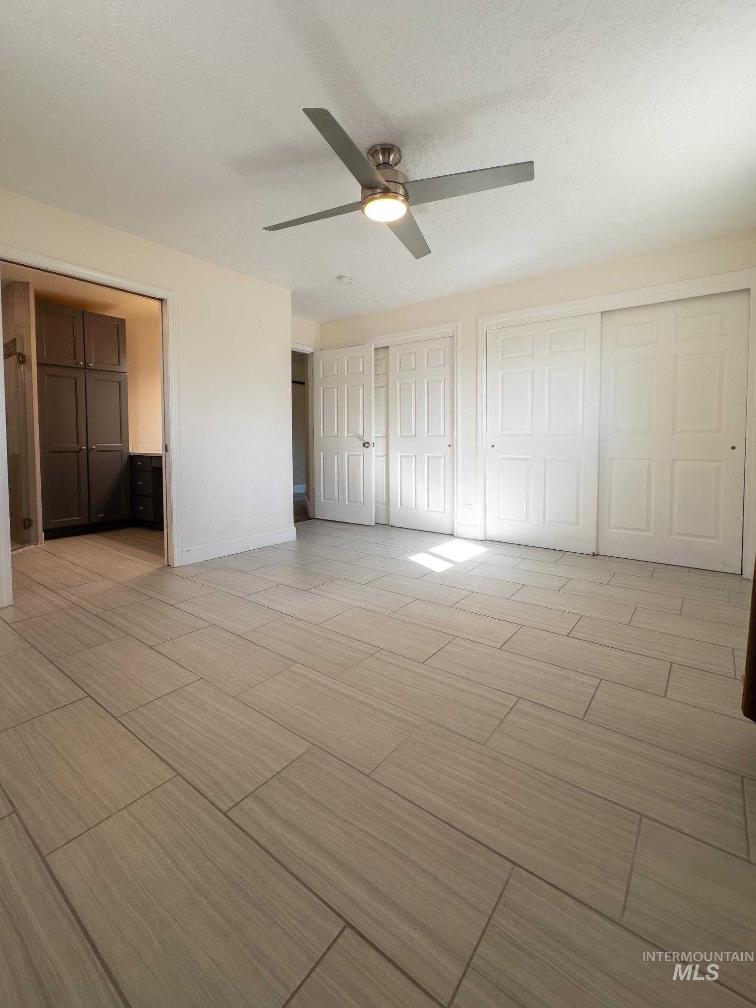 Primary bedroom featuring two closets and tiled floors