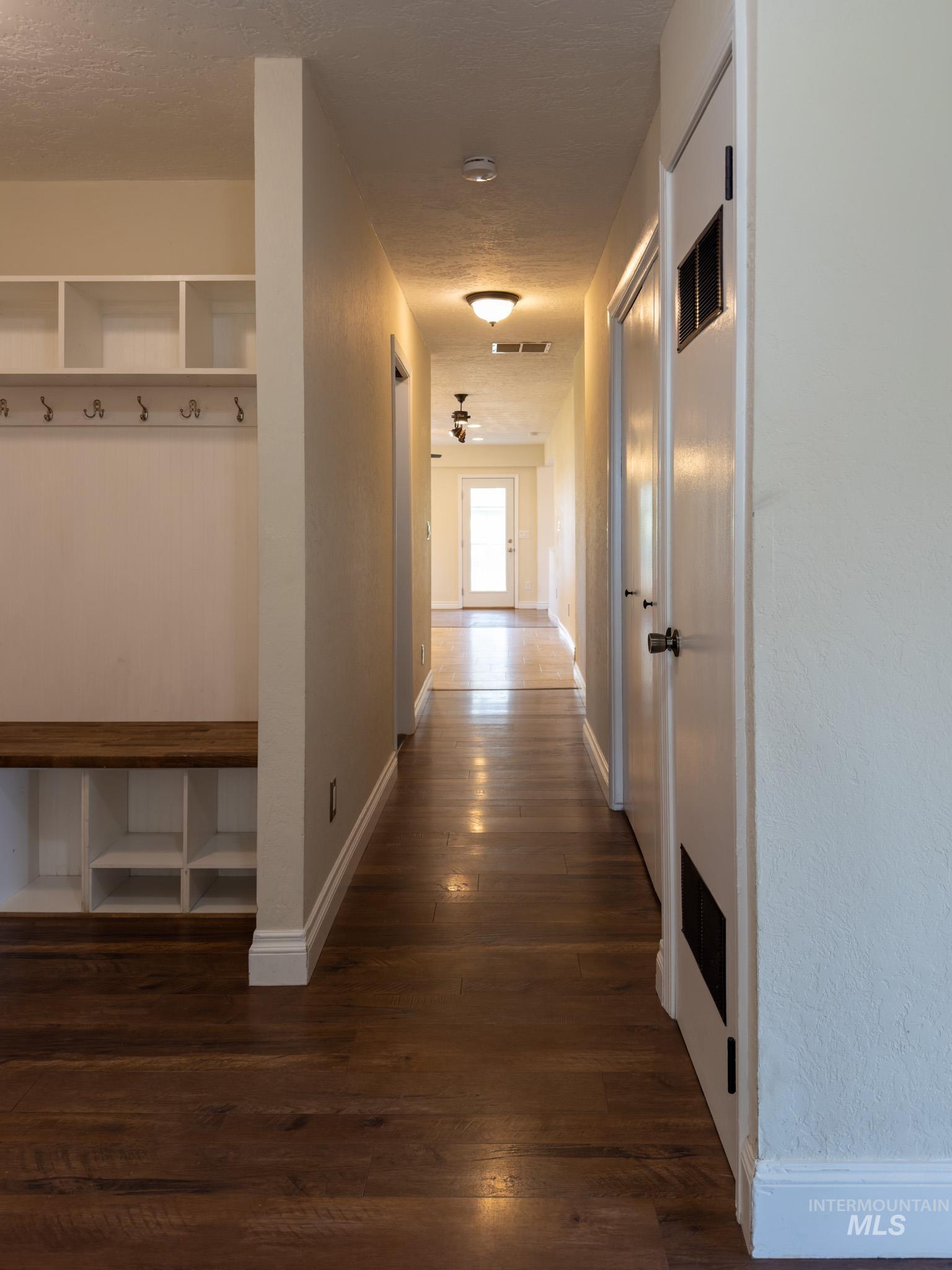 Corridor featuring dark wood finished floors and a textured ceiling