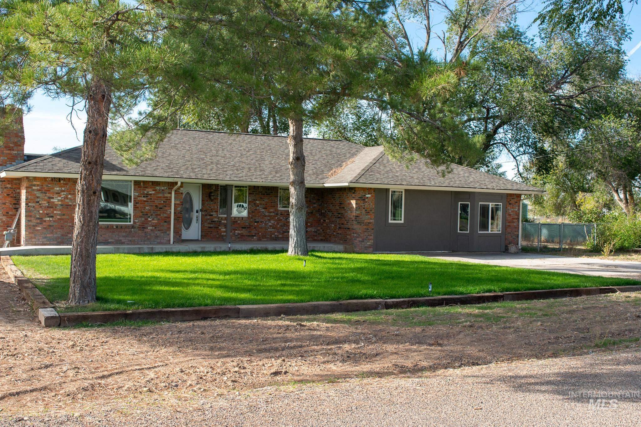 Ranch-style house featuring roof with shingles and brick siding