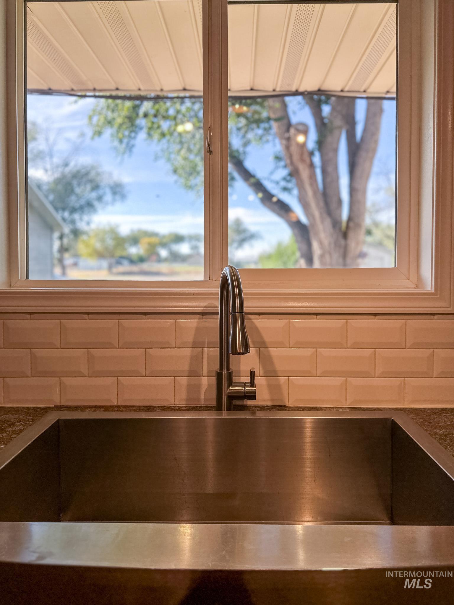 Kitchen view of tasteful backsplash and dark stone countertops